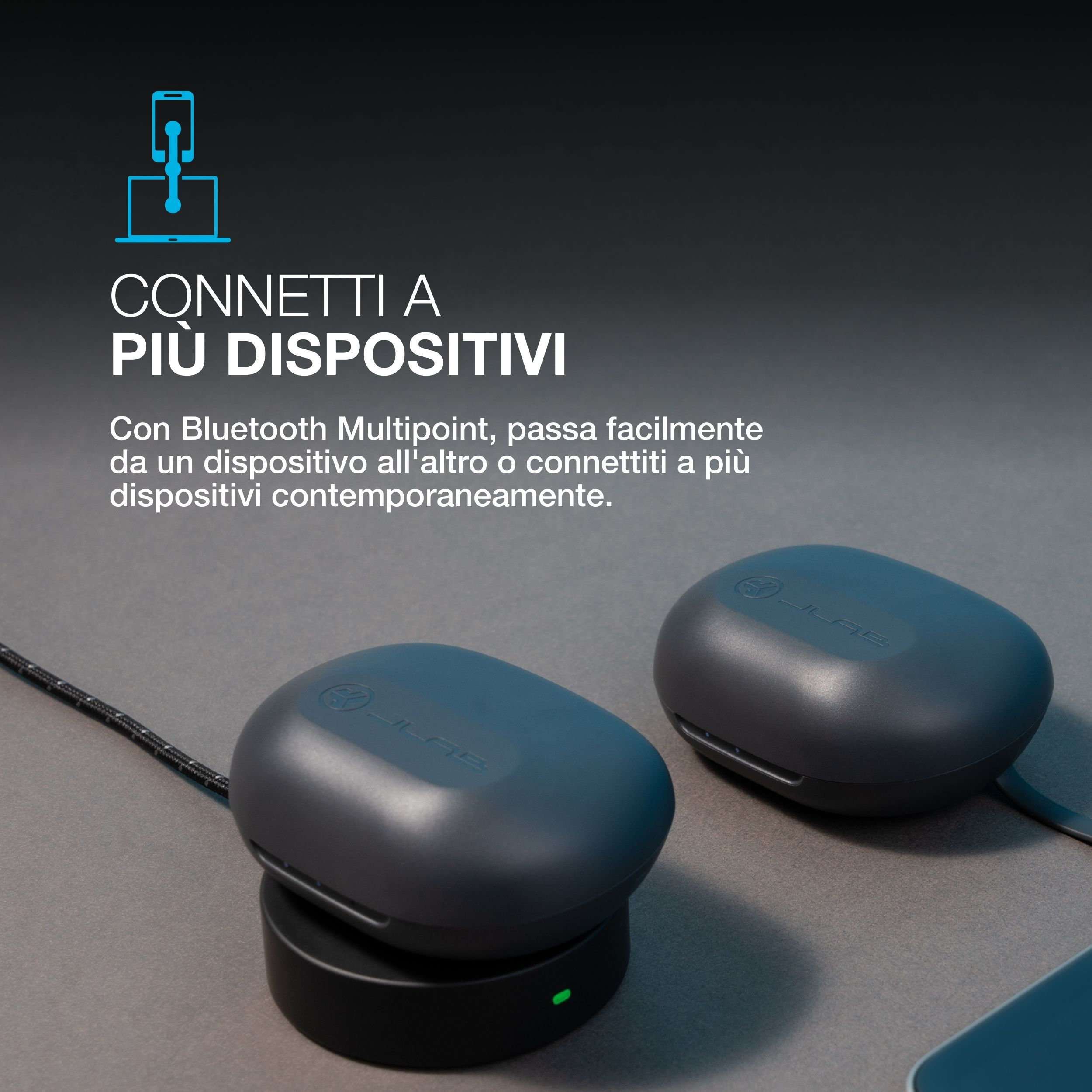 Dwa szare słuchawki z podstawkami ładującymi. Telefon i laptop połączone ikoną Bluetooth.