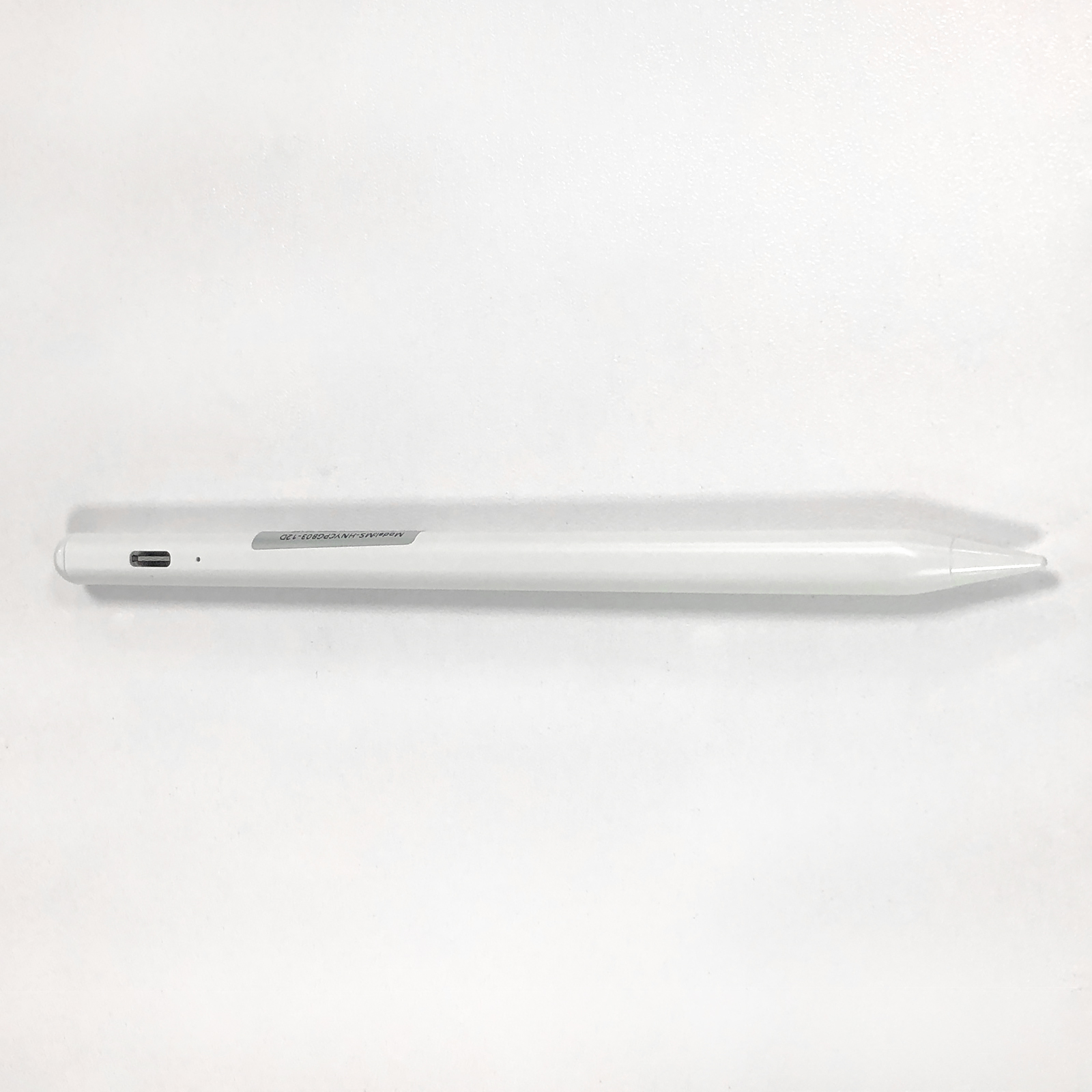 Biały rysik leży poziomo na białej powierzchni. Ma port ładowania i spiczastą końcówkę.