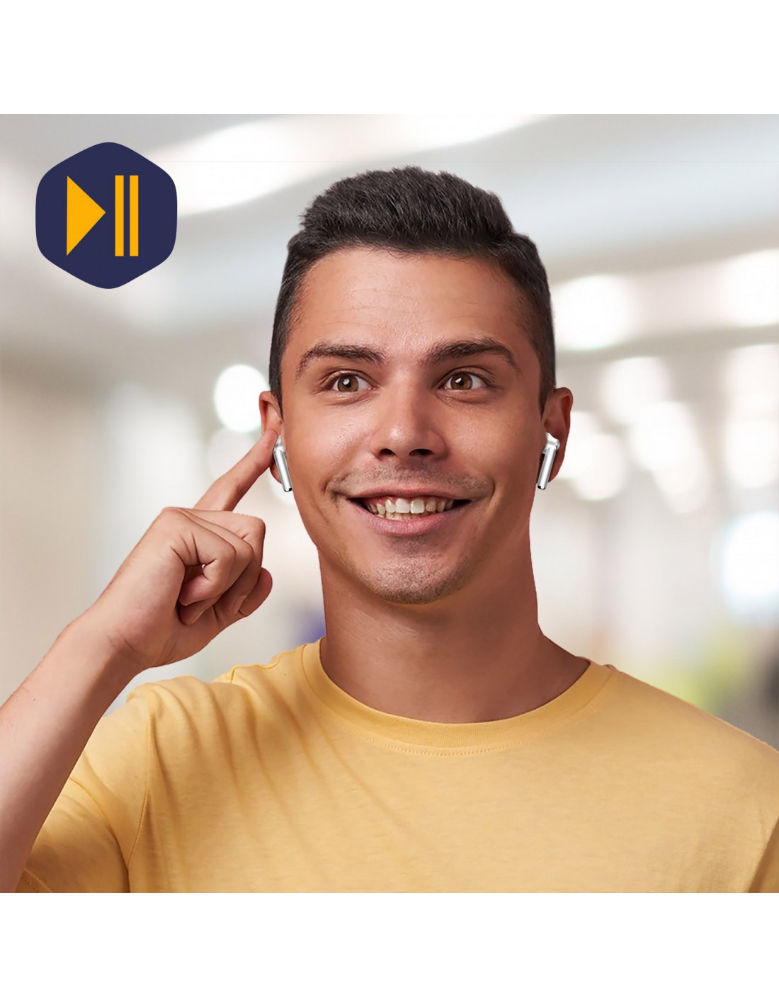 Un uomo sorridente con una maglietta gialla usa gli auricolari. Tocca l'auricolare con il dito indice. Lo sfondo è sfocato.