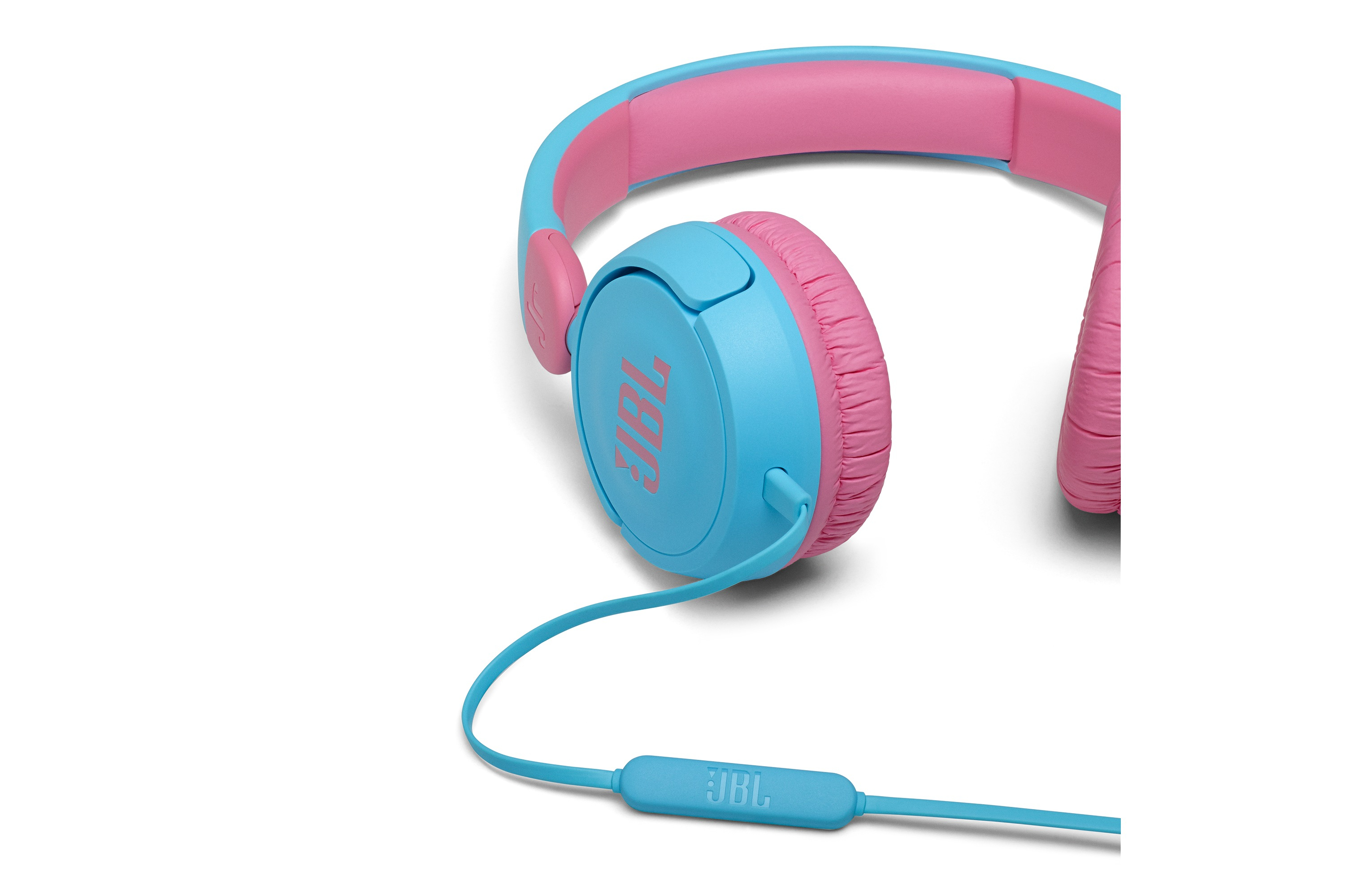 Niebieskie i różowe słuchawki JBL na białym tle. Słuchawki na białej powierzchni, z kablem.