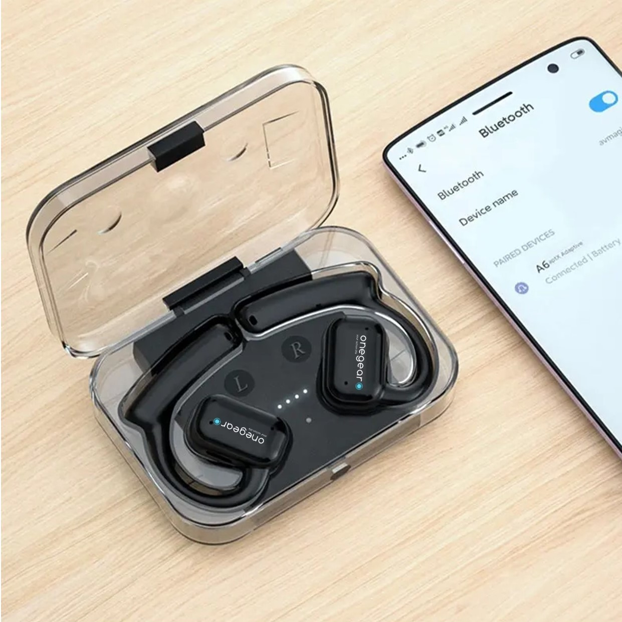 Auricolari neri in un astuccio, accanto a un telefono che mostra le impostazioni Bluetooth. Gli auricolari sono etichettati 'onegear'.