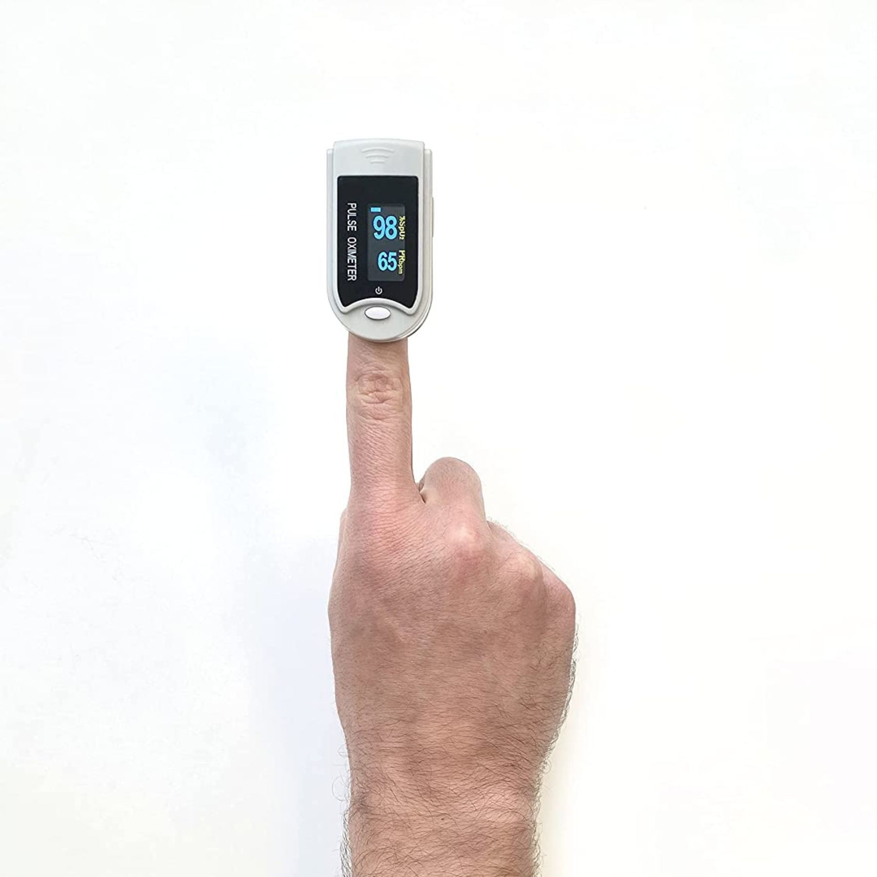 Ein Pulsoximeter auf einem Finger zeigt 98 % SpO2 und 65 bpm. Die Hand vor weißem Hintergrund.