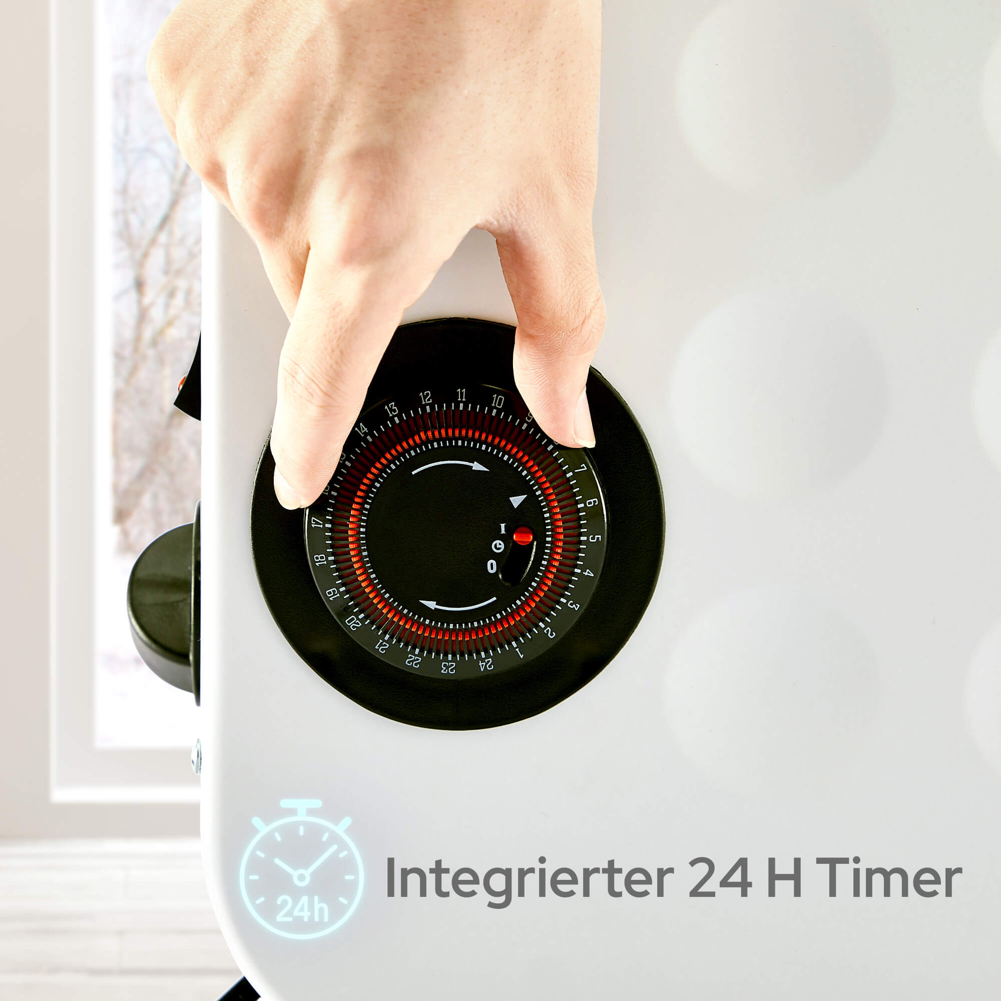 Eine Hand dreht einen Timer an einem weißen Gerät. Der Timer ist schwarz mit roten Markierungen und Zahlen.