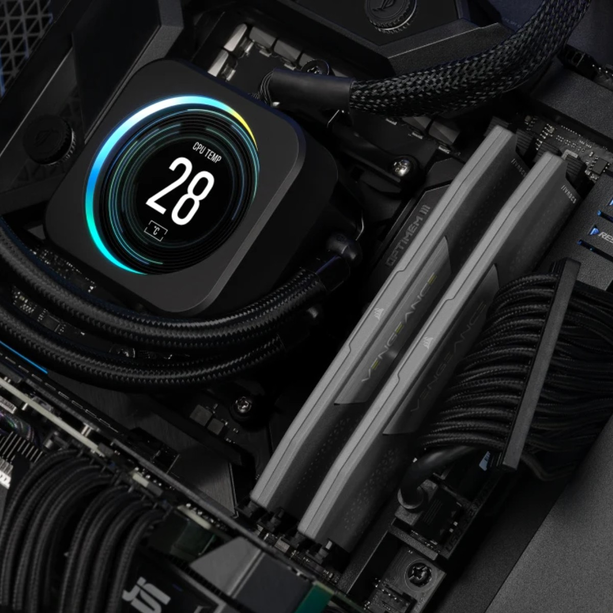 Nahaufnahme von Computerkomponenten. CPU-Kühler zeigt Temperatur. RAM-Riegel und Kabel sind sichtbar.