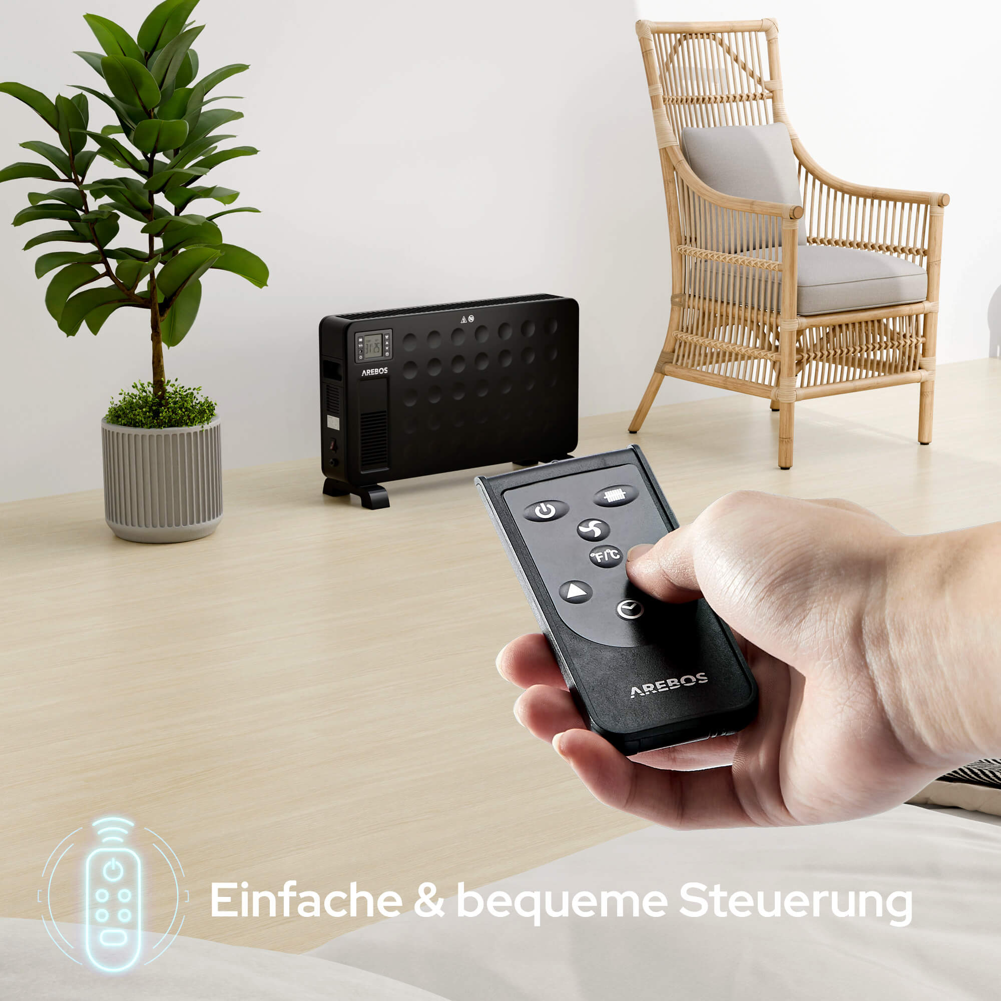 Eine Hand hält eine schwarze Fernbedienung und steuert eine schwarze Heizung. Eine Pflanze und ein Stuhl befinden sich im Hintergrund.