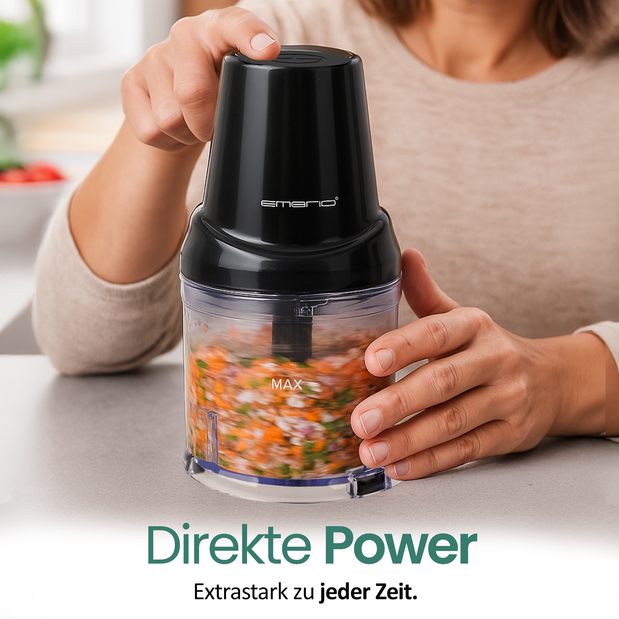 Eine Person benutzt einen schwarzen Food-Processor. Gehacktes Gemüse befindet sich im Behälter. Der Text 'Direkte Power' steht unten.