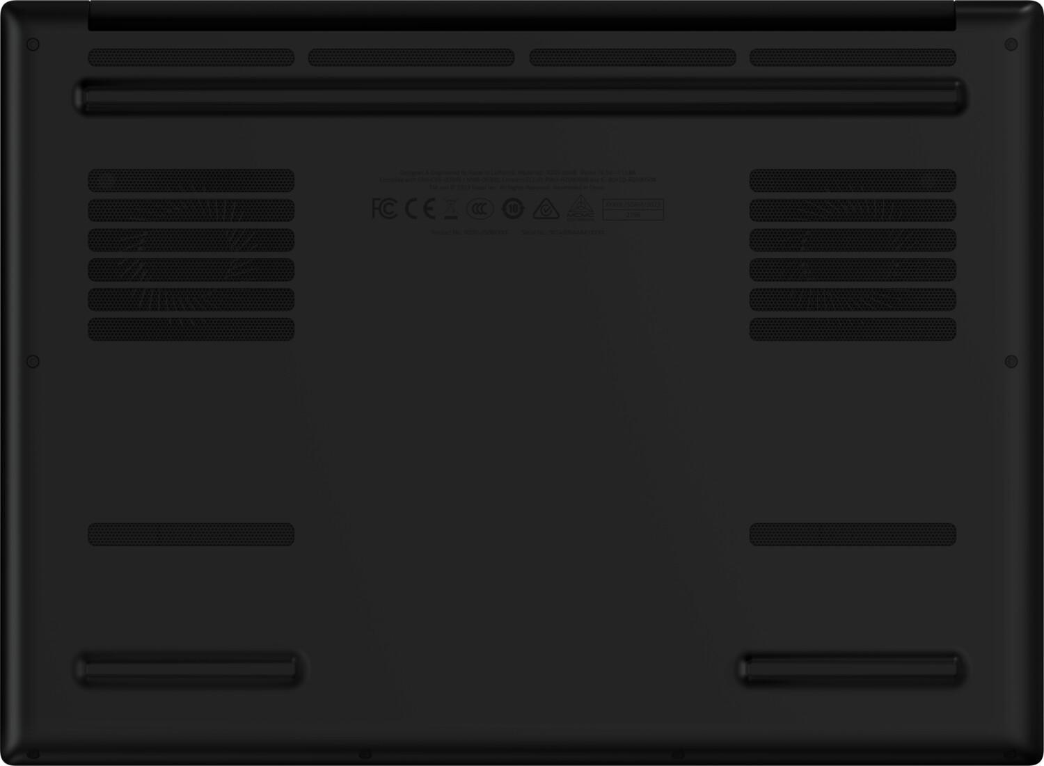 Spód czarnego laptopa. Ma kratki wentylacyjne, cztery gumowe nóżki i wydrukowane informacje regulacyjne.