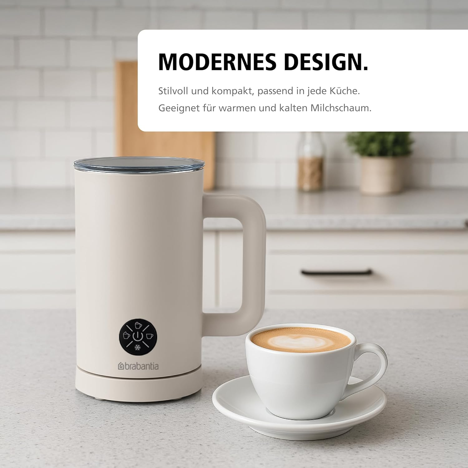 Ein beiger Milchaufschäumer und eine Kaffeetasse auf einer Arbeitsplatte. Text oben: MODERNES DESIGN.