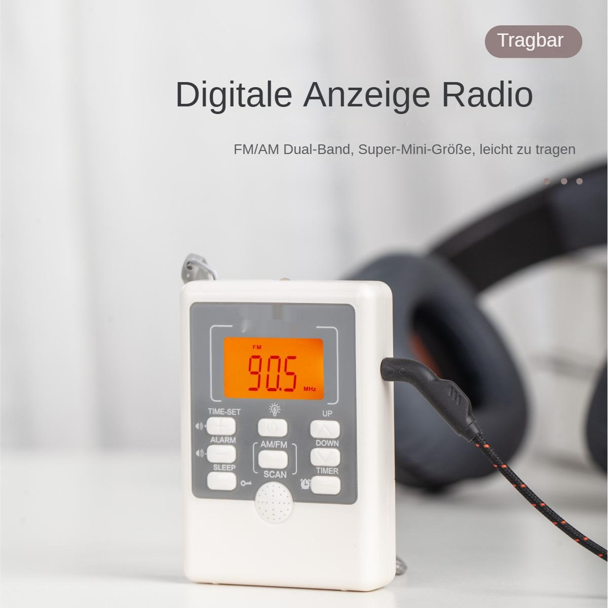 Ein weißes Digitalradio zeigt 90,5 MHz an. Knöpfe sind Zeiteinstellung, Alarm, AM/FM, Schlaf, Scan, hoch, runter und Timer. Kopfhörer im Hintergrund.