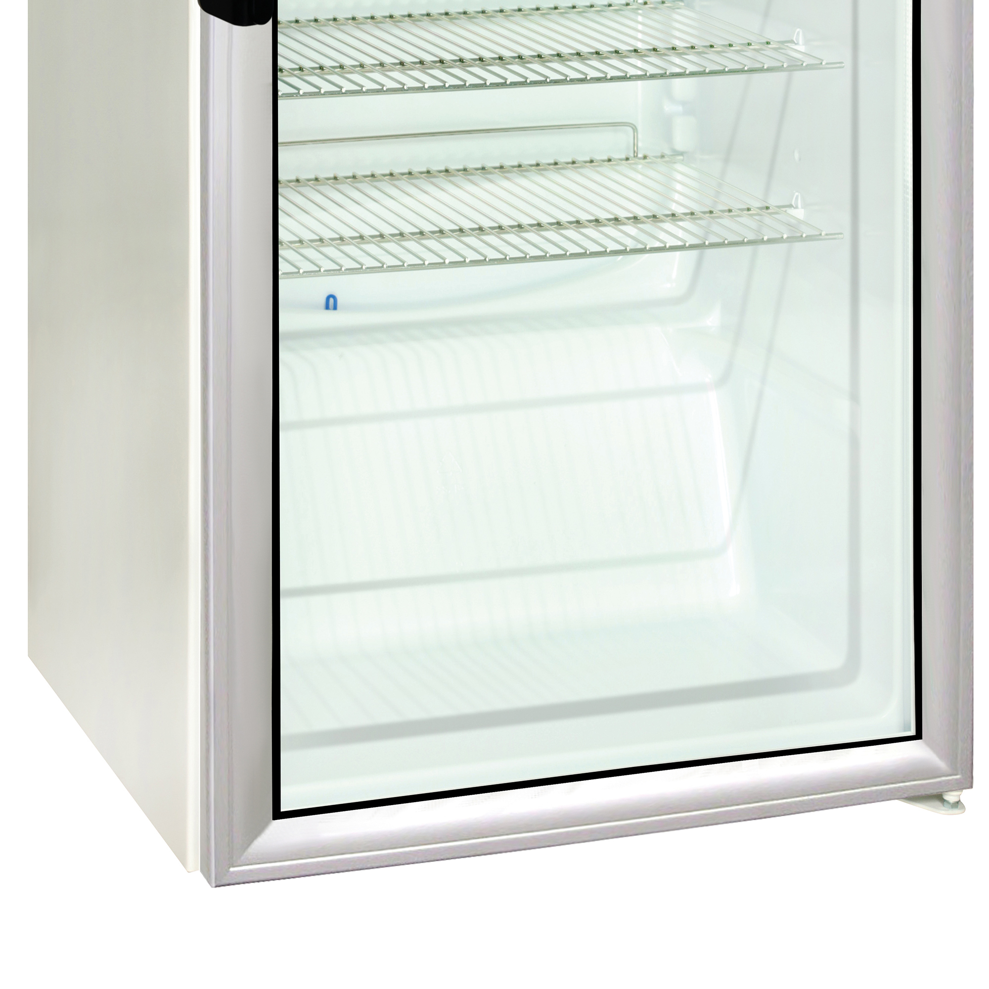Nahaufnahme eines Mini-Kühlschranks. Er hat eine Glastür mit Regalen im Inneren. Der Kühlschrank ist weiß.