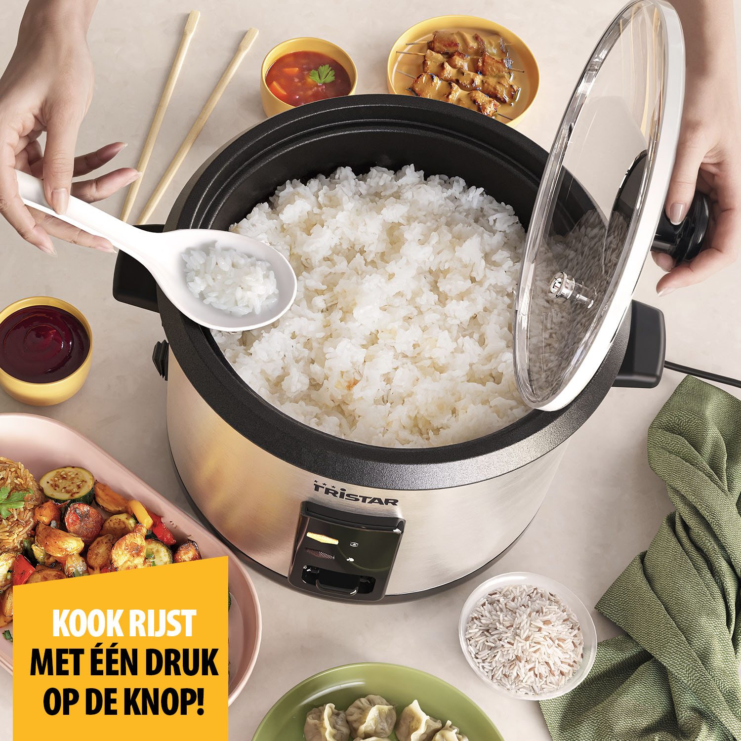 A rice cooker with cooked rice. Various side dishes like vegetables, dumplings, and sauces are around. A hand holds a spoon with rice.