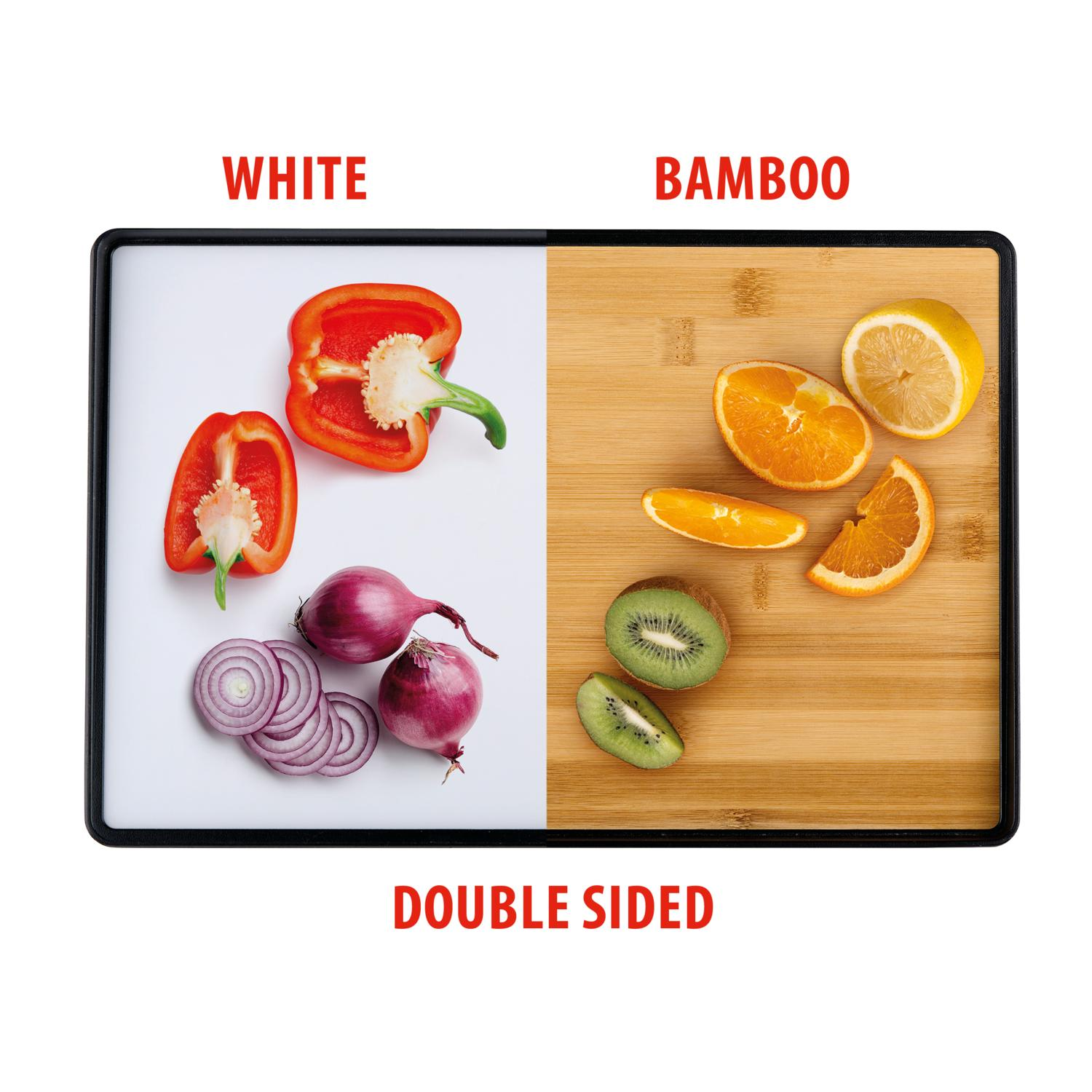 A double-sided cutting board with fruits and vegetables. Red bell peppers, red onion and sliced kiwi, oranges and a lemon.