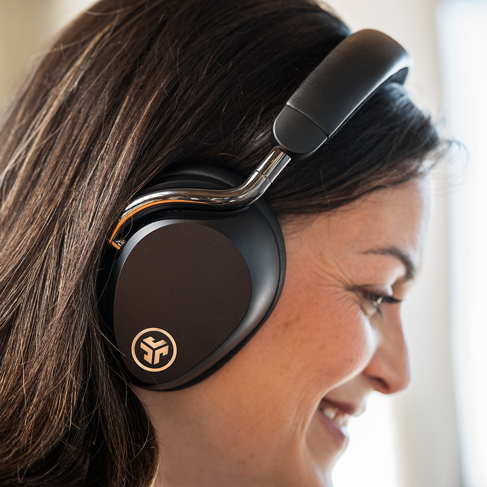 Une femme portant un casque noir sourit. Le casque est sur sa tête, obscurcissant une partie de ses cheveux. L'arrière-plan est flou.
