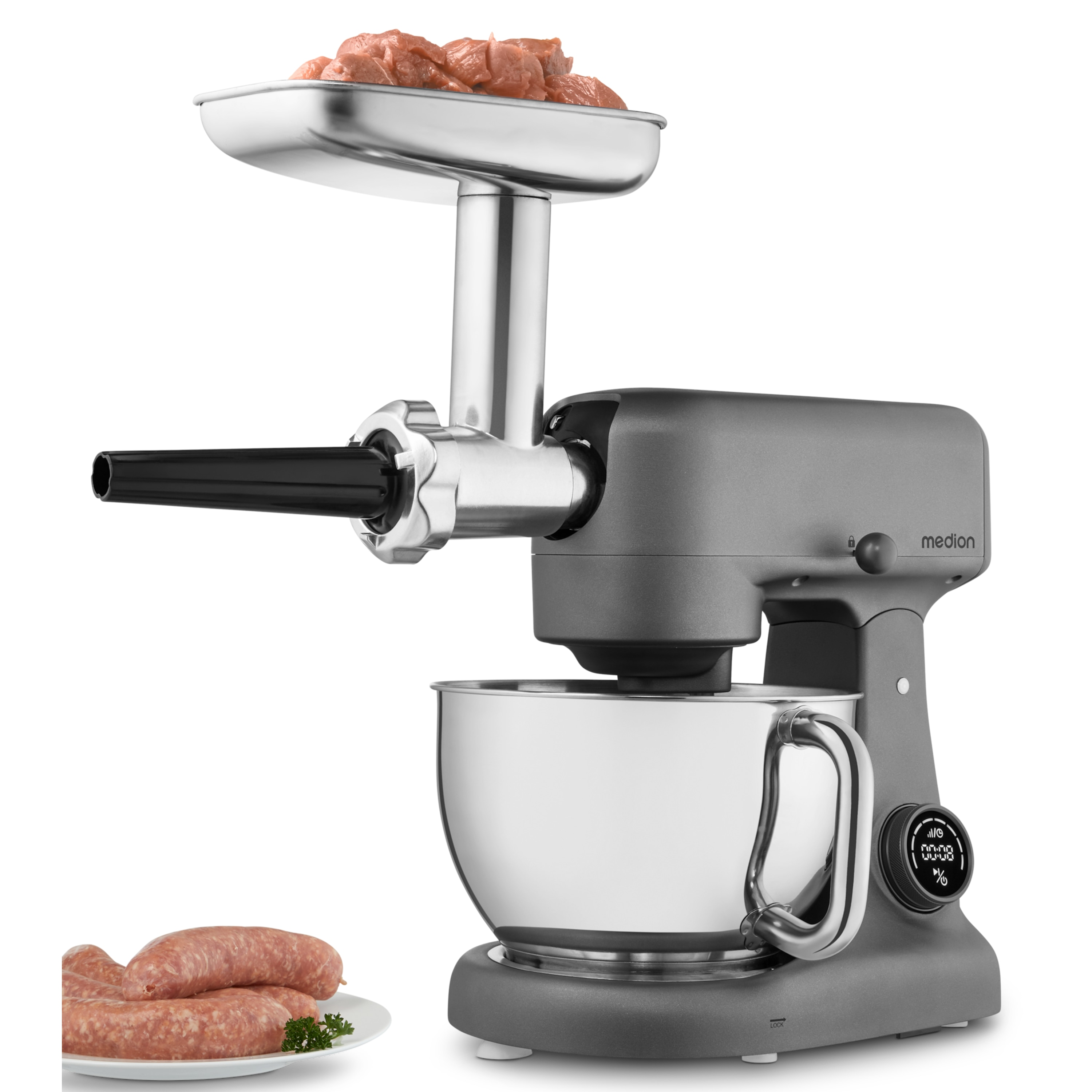 Ein grauer Food Processor mit Fleischwolfaufsatz. Gewürfeltes Fleisch liegt im Trichter. Würstchen auf einem Teller.