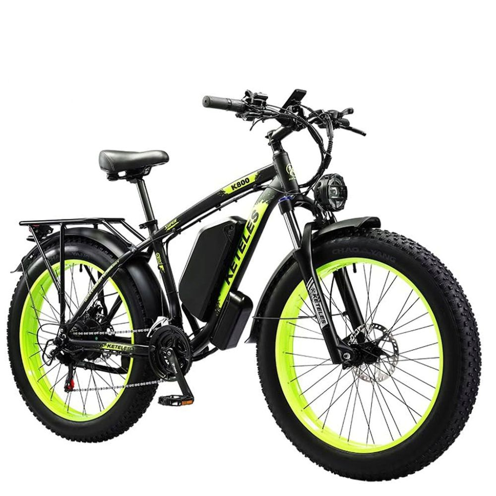 Una bici elettrica. È nera con cerchi verdi e un sedile nero. La bici ha una batteria e un faro, e c'è scritto KETELES.