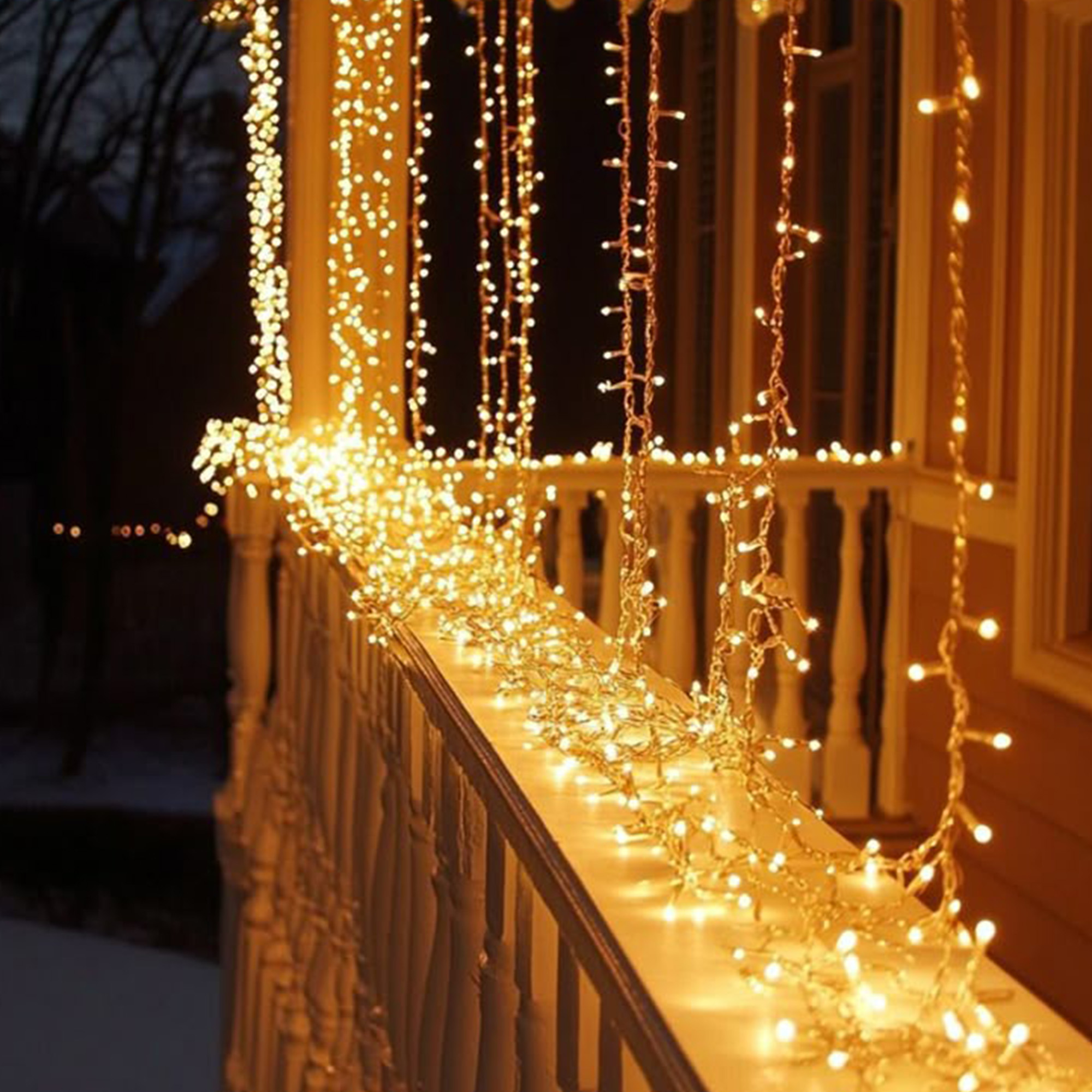 Un porche está decorado con hileras de luces blancas cálidas. La escena está iluminada en la oscuridad.