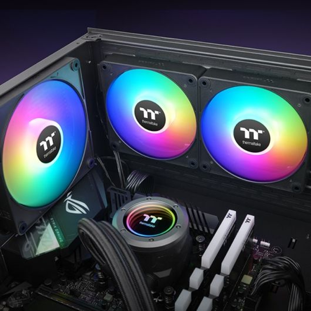 Composants PC avec ventilateurs RVB. Les ventilateurs sont de couleur arc-en-ciel. Le refroidisseur de CPU et la RAM sont également visibles.