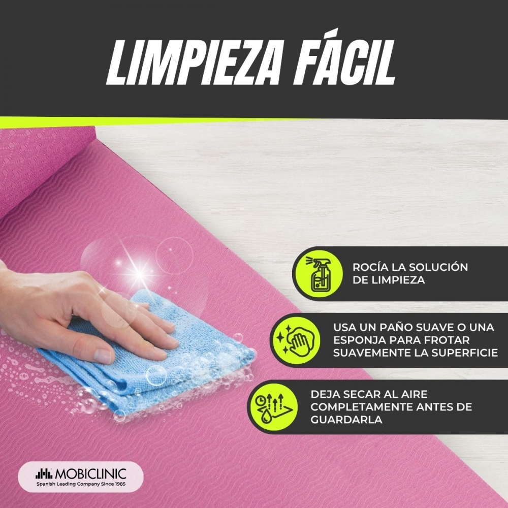 Una mano limpia una esterilla de yoga rosa con un paño azul. El texto describe los pasos de limpieza: rociar, frotar con esponja, secar al aire.