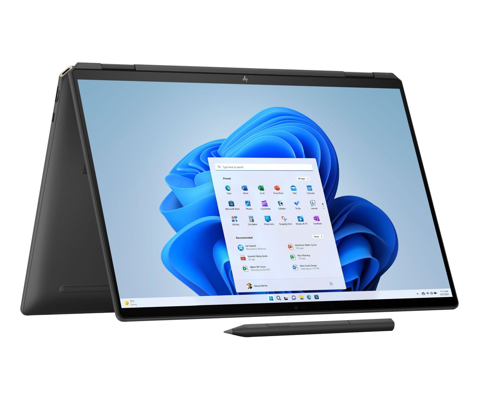 Laptop z otwartym interfejsem Windows 11. Pióro leży na stole. Ekran wyświetla ikony aplikacji i menu Start.