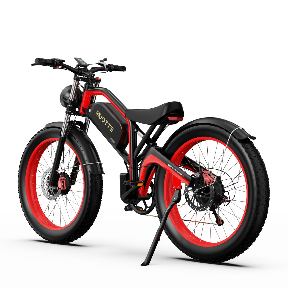 Una bicicleta eléctrica roja y negra con neumáticos grandes. Tiene un asiento negro, un faro y un caballete. La marca es DUOTTS.