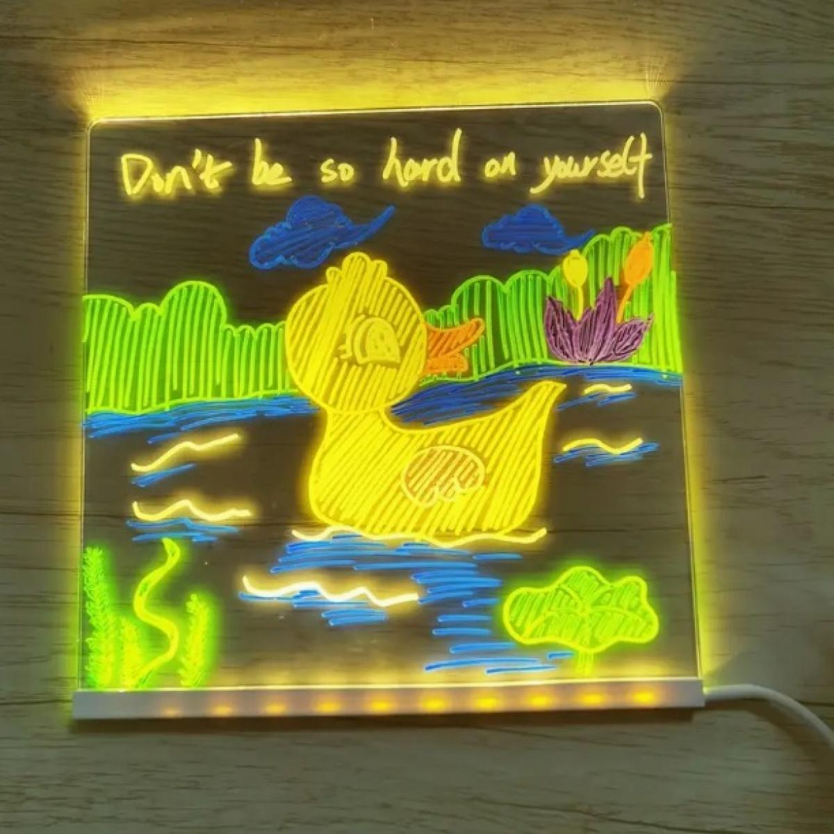 Beleuchtete Zeichnung mit gelber Ente im Wasser. Text: 'Sei nicht so hart zu dir selbst'. Bunte Pflanzen und Wolken.