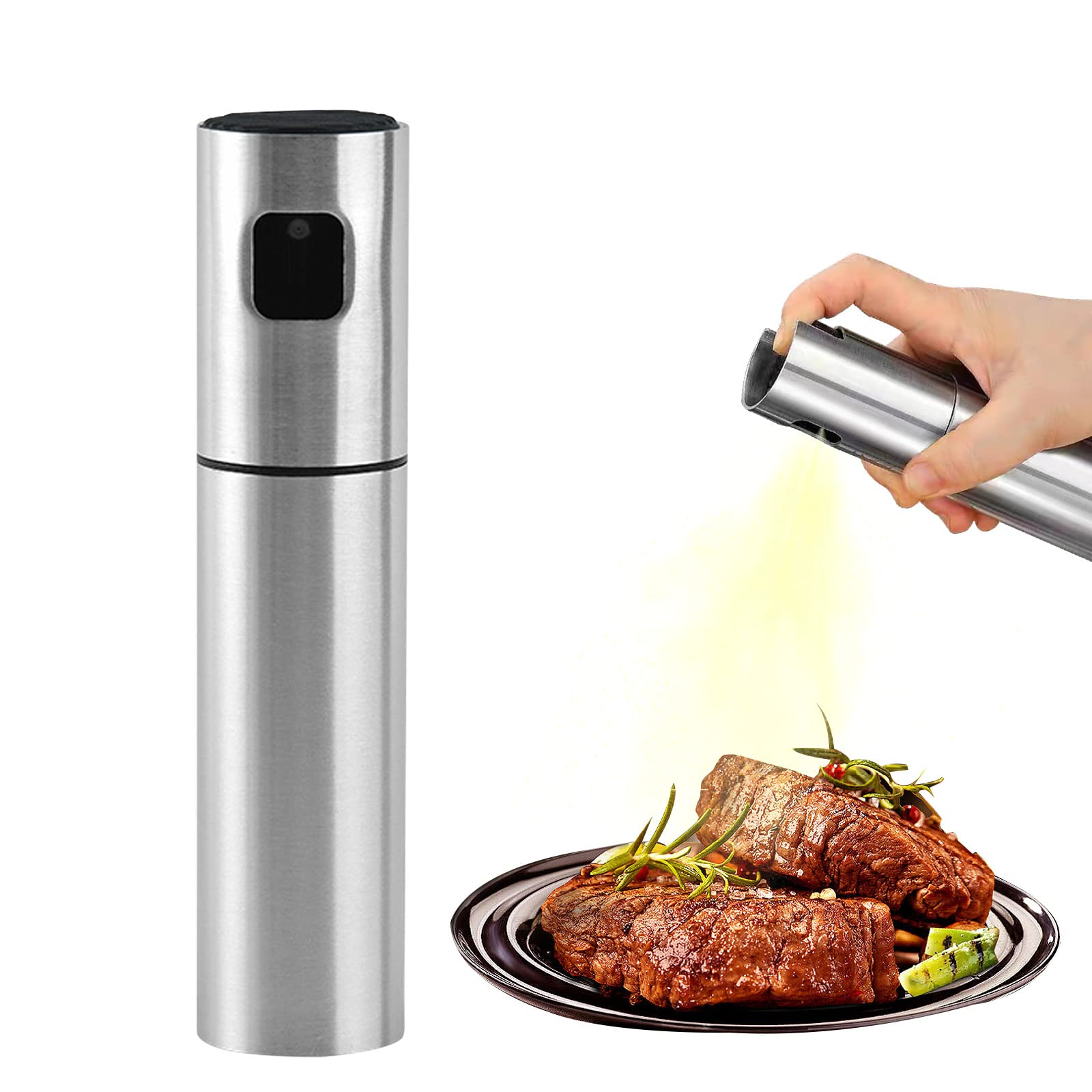 Eine Hand sprüht Öl aus einem Edelstahlzerstäuber auf Steak. Steak auf einem Teller mit Grünzeug. Ein weiterer Sprüher steht.