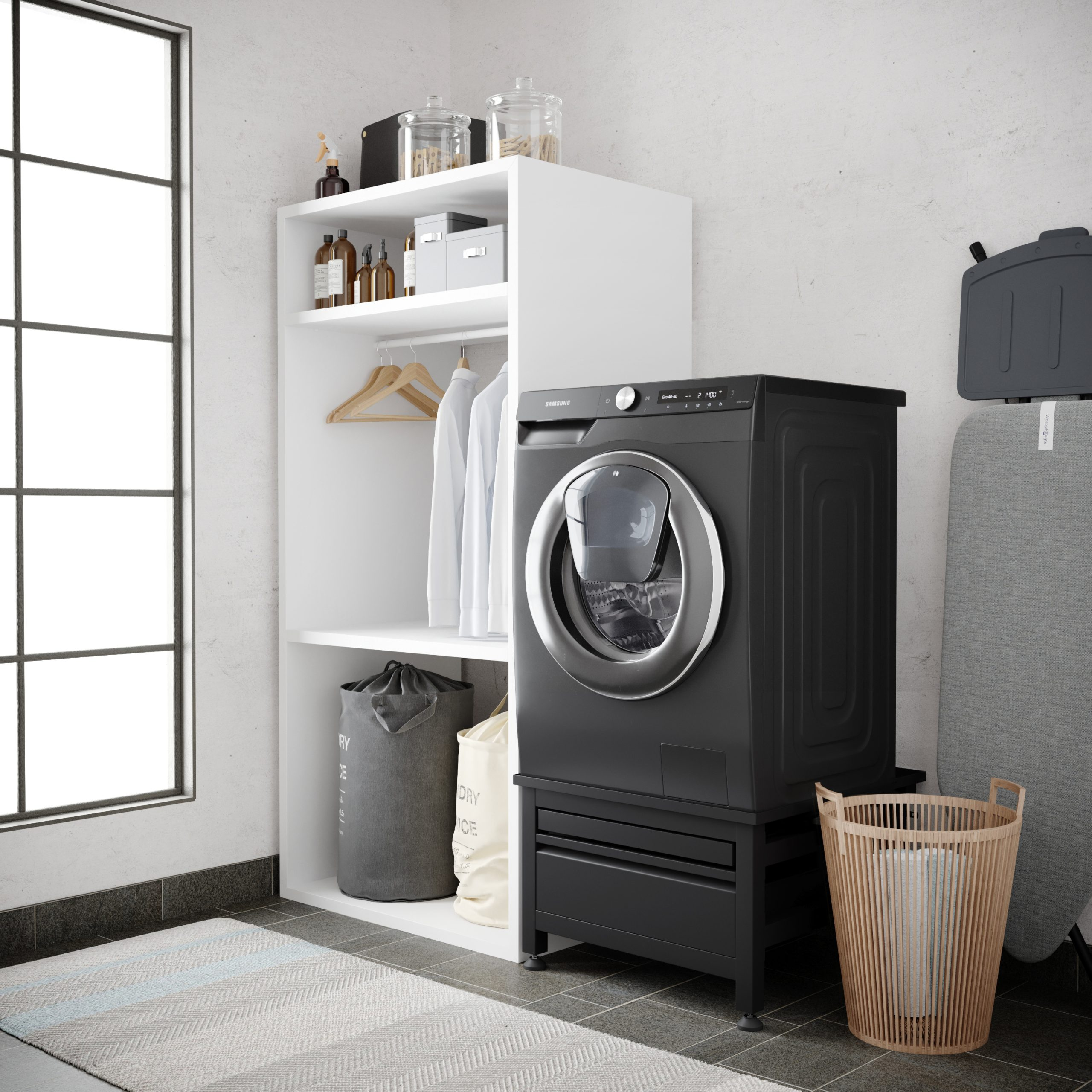 Een wasruimte met een wasmachine, plank en strijkplank. De machine is zwart, de plank is wit.