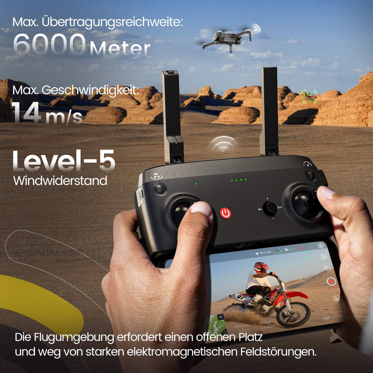 Eine Person hält eine Drohnenfernbedienung mit Bildschirm, der ein Dirtbike zeigt. Eine Drohne fliegt über einer Wüstenlandschaft.