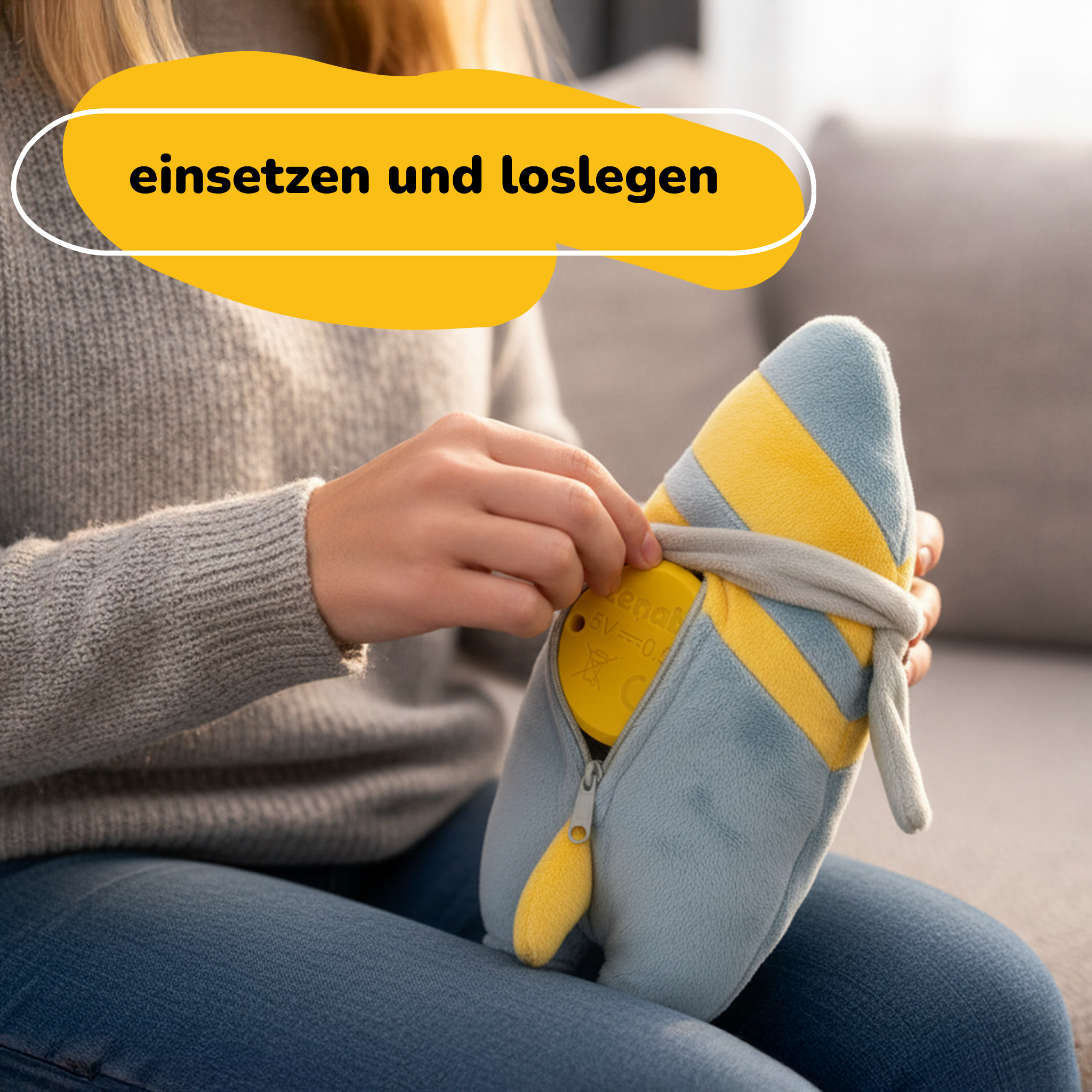 Person hält ein blau-gelbes Stofftier mit Reißverschluss. Oben steht 'einsetzen und loslegen'.