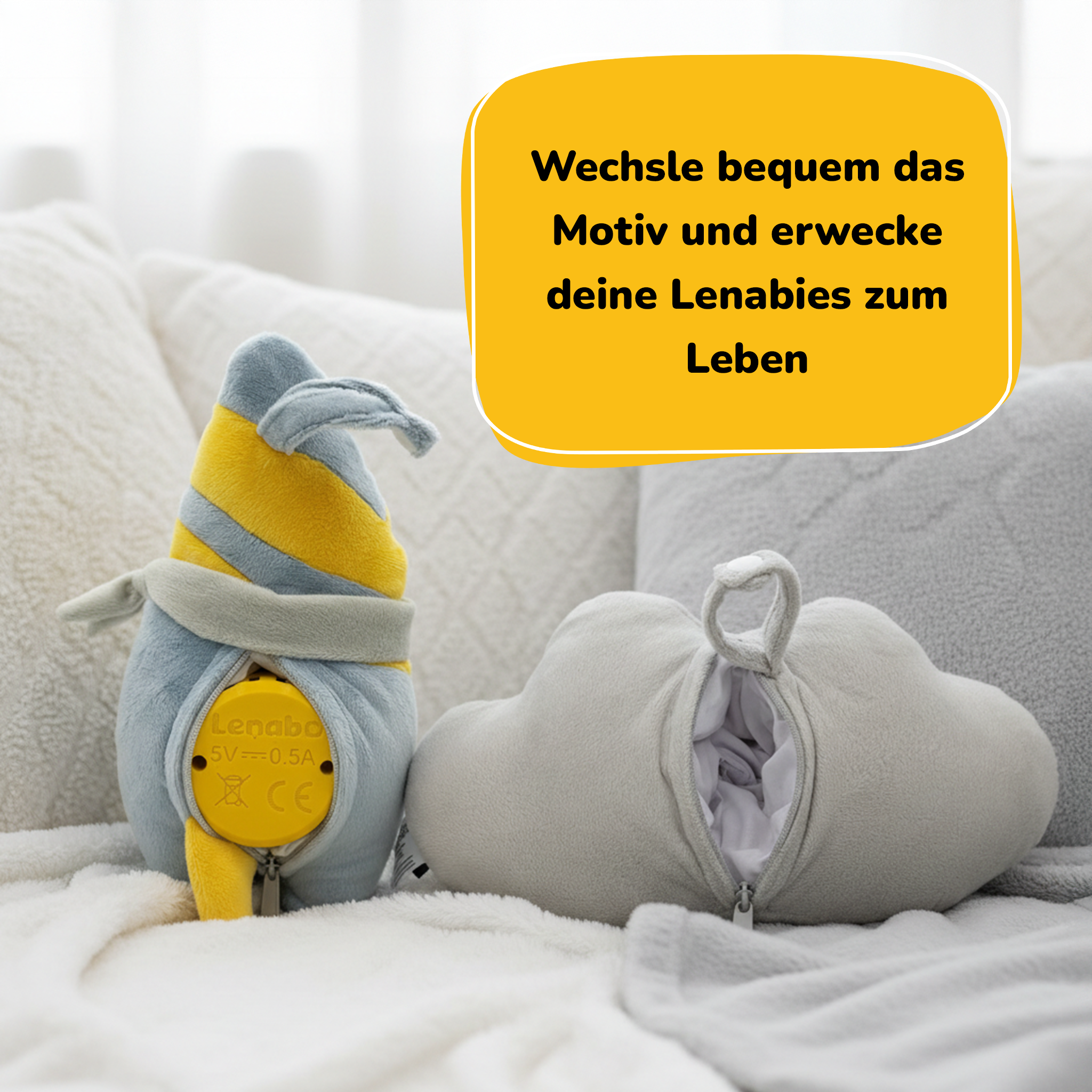 Das Bild zeigt ein Plüschtier mit gelb-grauem Design neben einem wolkenförmigen Kissen auf einer weißen Decke.