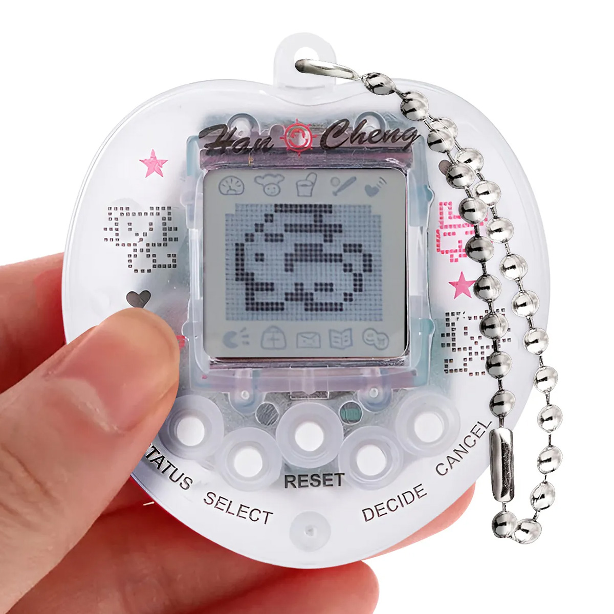 Eine Hand hält ein klares, herzförmiges Tamagotchi-ähnliches Gerät. Der Bildschirm zeigt einen verpixelten Charakter. Eine Kette hängt von oben.