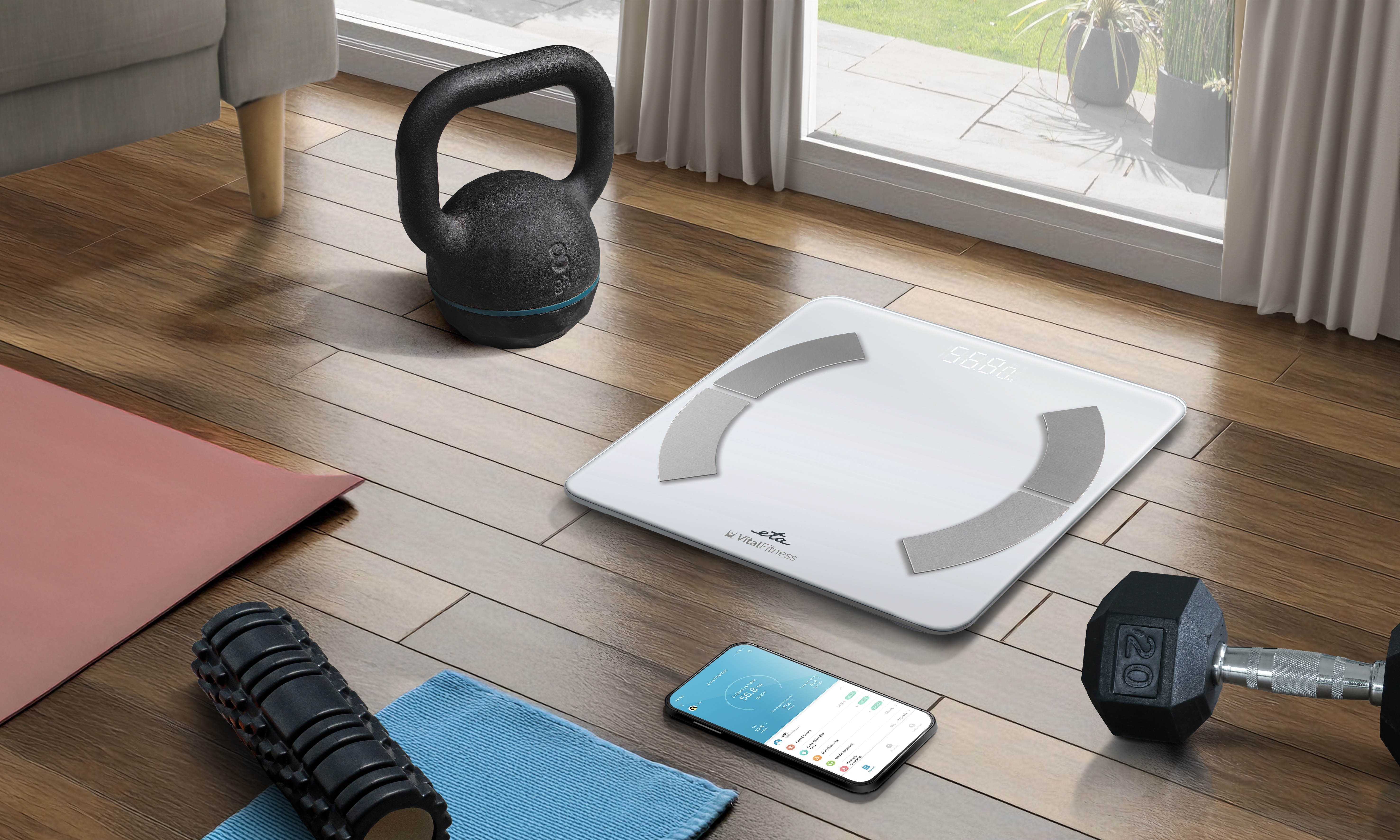 Eine Fitnessszene mit Waage, Hantel, Kettlebell, Matte, Faszienrolle und Telefon. Der Hintergrund zeigt ein Fenster mit Pflanzen.
