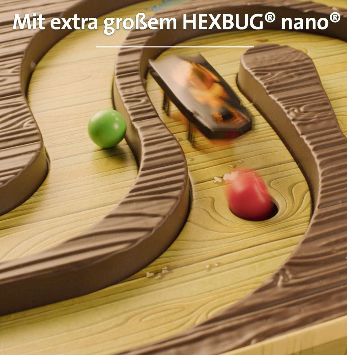 Ein Spielbrett mit einem Hexbug, grünen und roten Kugeln. Das Brett hat braune Bahnen und ein Holzmuster.