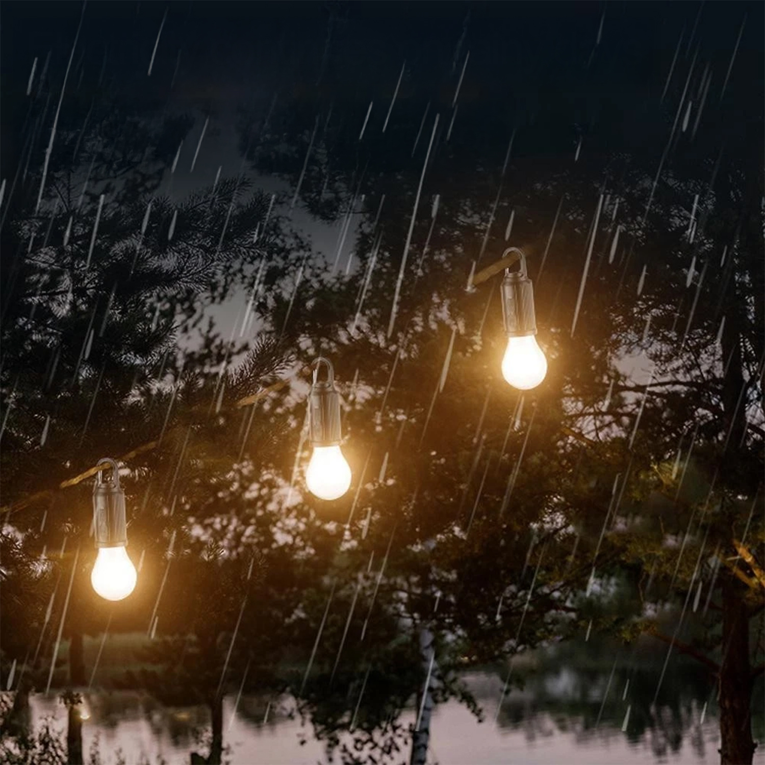 Tre lampadine illuminate appese a un albero sotto la pioggia. Lo sfondo mostra una foresta scura e un lago.