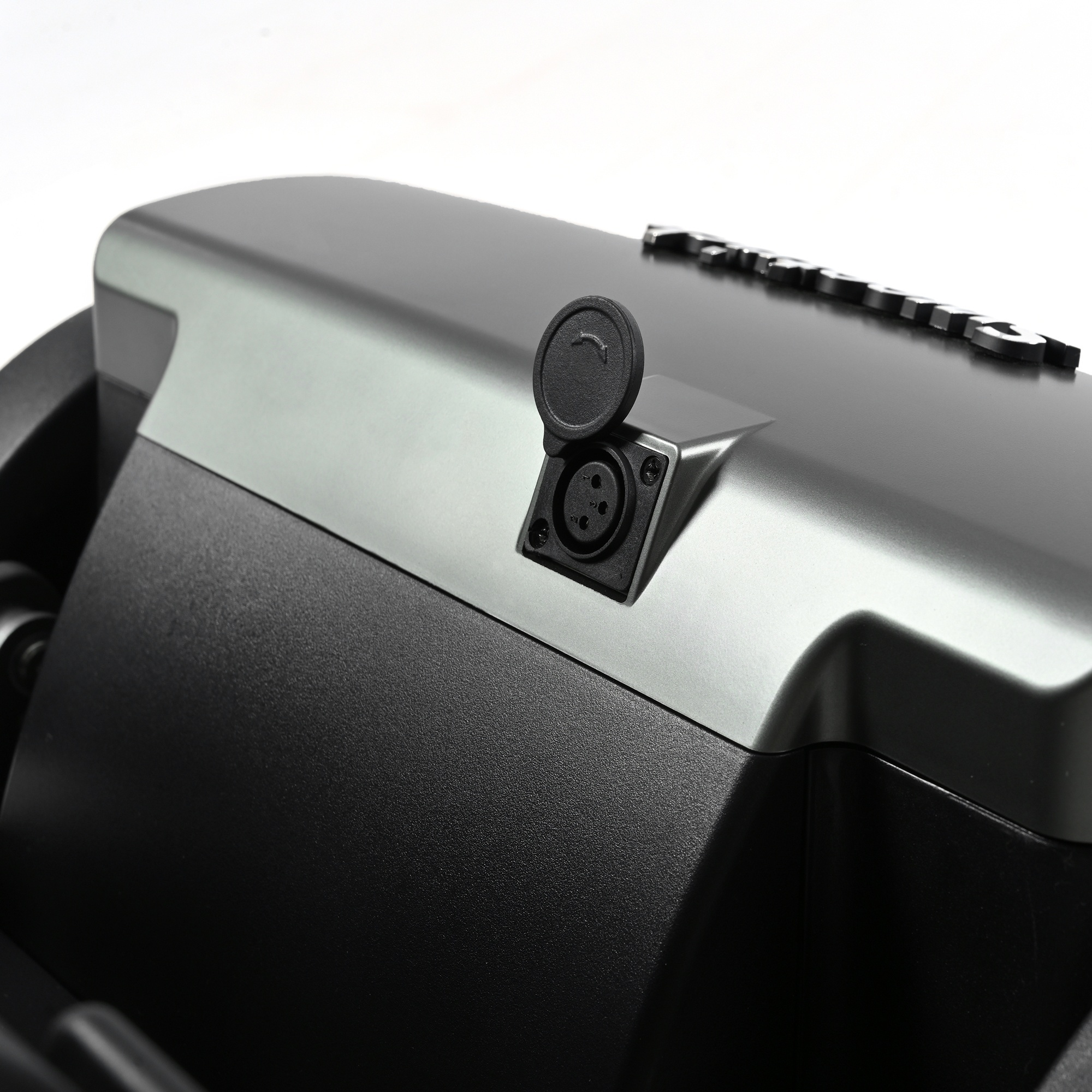 Zbliżenie czarno-szarego urządzenia z portem ładowania i pokrywą. Tło jest białe.