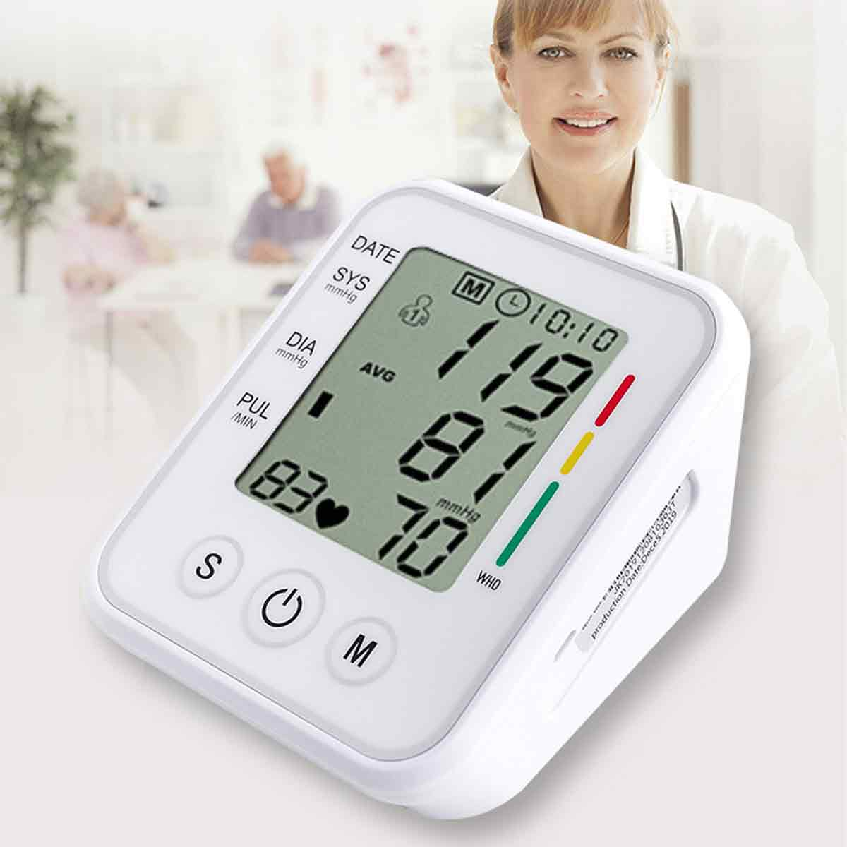 Ein weißes Blutdruckmessgerät zeigt Werte von 119/81 mmHg an. Im Hintergrund steht eine lächelnde Frau.