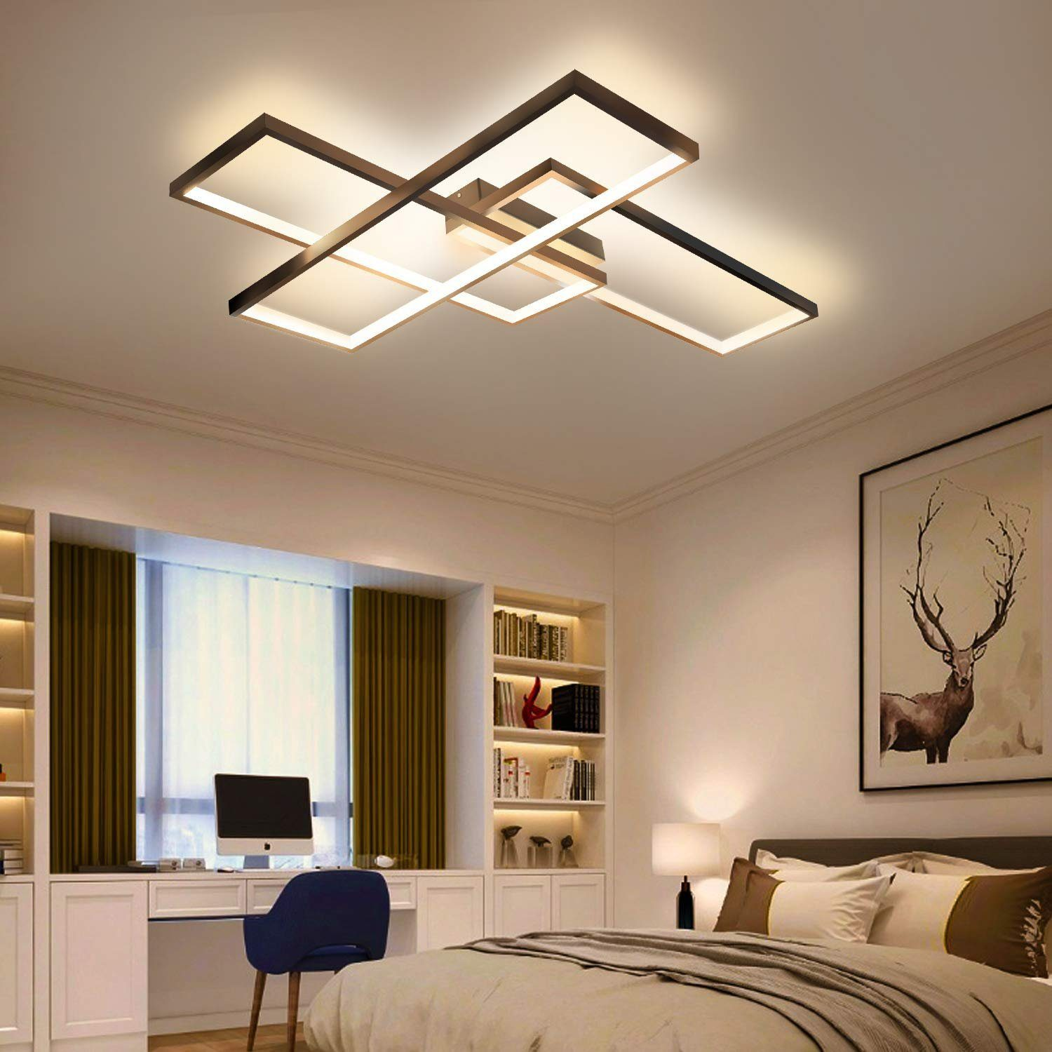 Una camera da letto moderna con una lampada da soffitto complessa. Una scrivania con computer, librerie, un letto e un'immagine di cervo sono presenti.