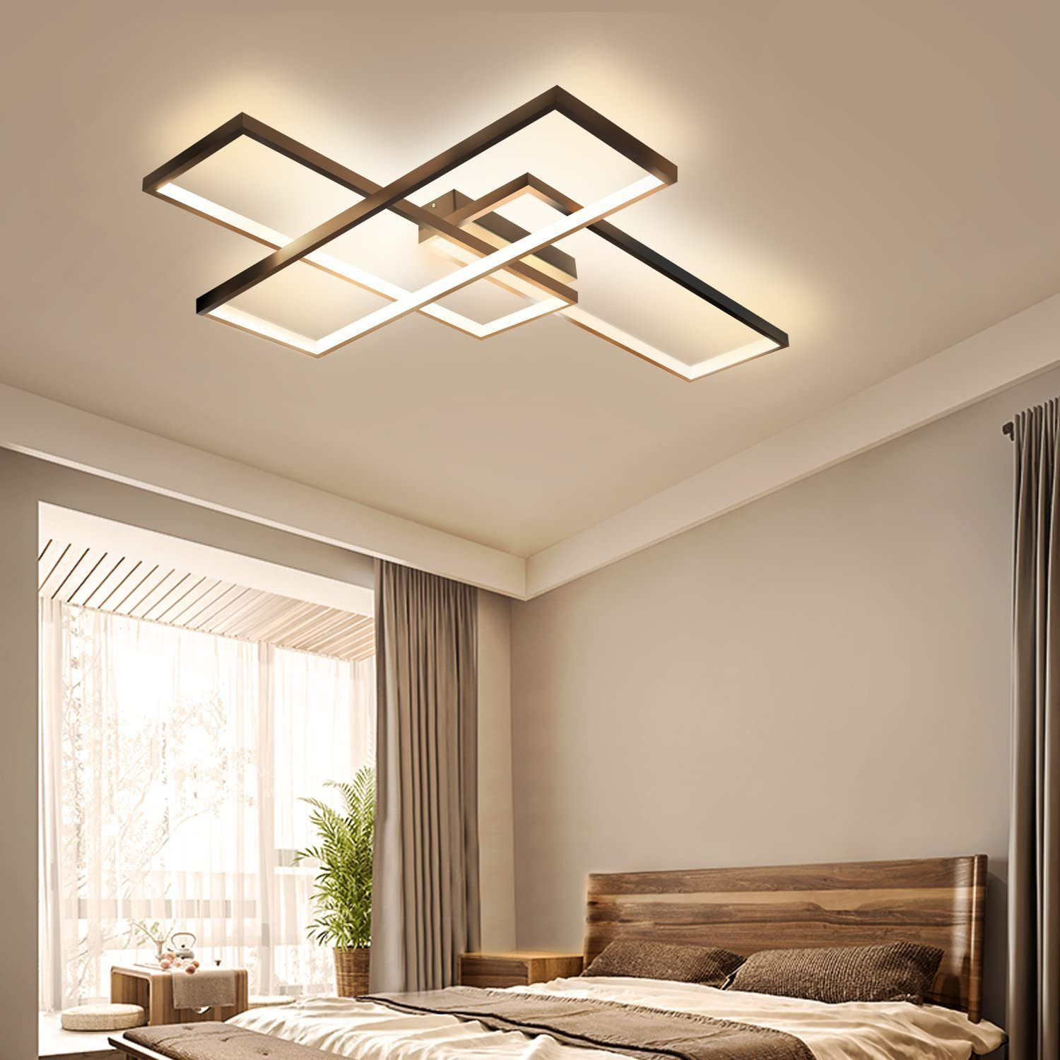 Camera da letto con luci a soffitto. Finestra con tende e letto con testiera in legno. Una pianta è visibile vicino alla finestra.