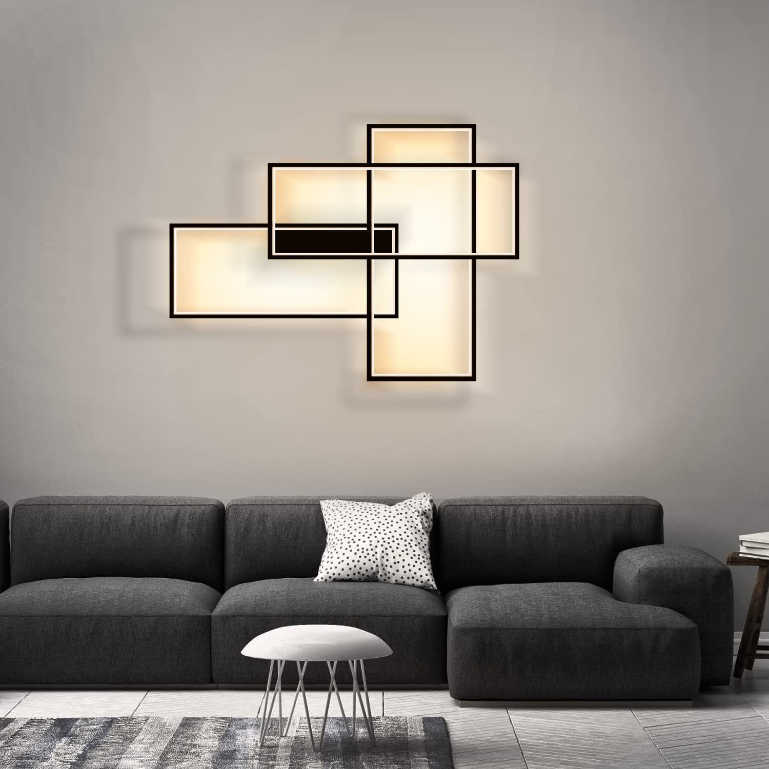 Soggiorno moderno con divano grigio, lampada geometrica, sgabello bianco e cuscino fantasia.