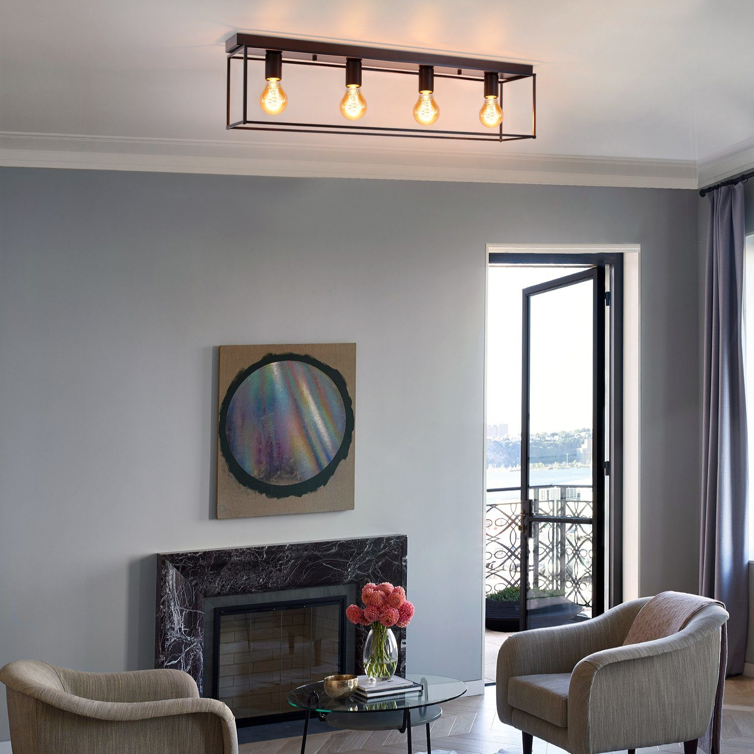 Soggiorno con luci a soffitto, camino, sedie e tavolino in vetro. Un dipinto è appeso al muro e un balcone è visibile.