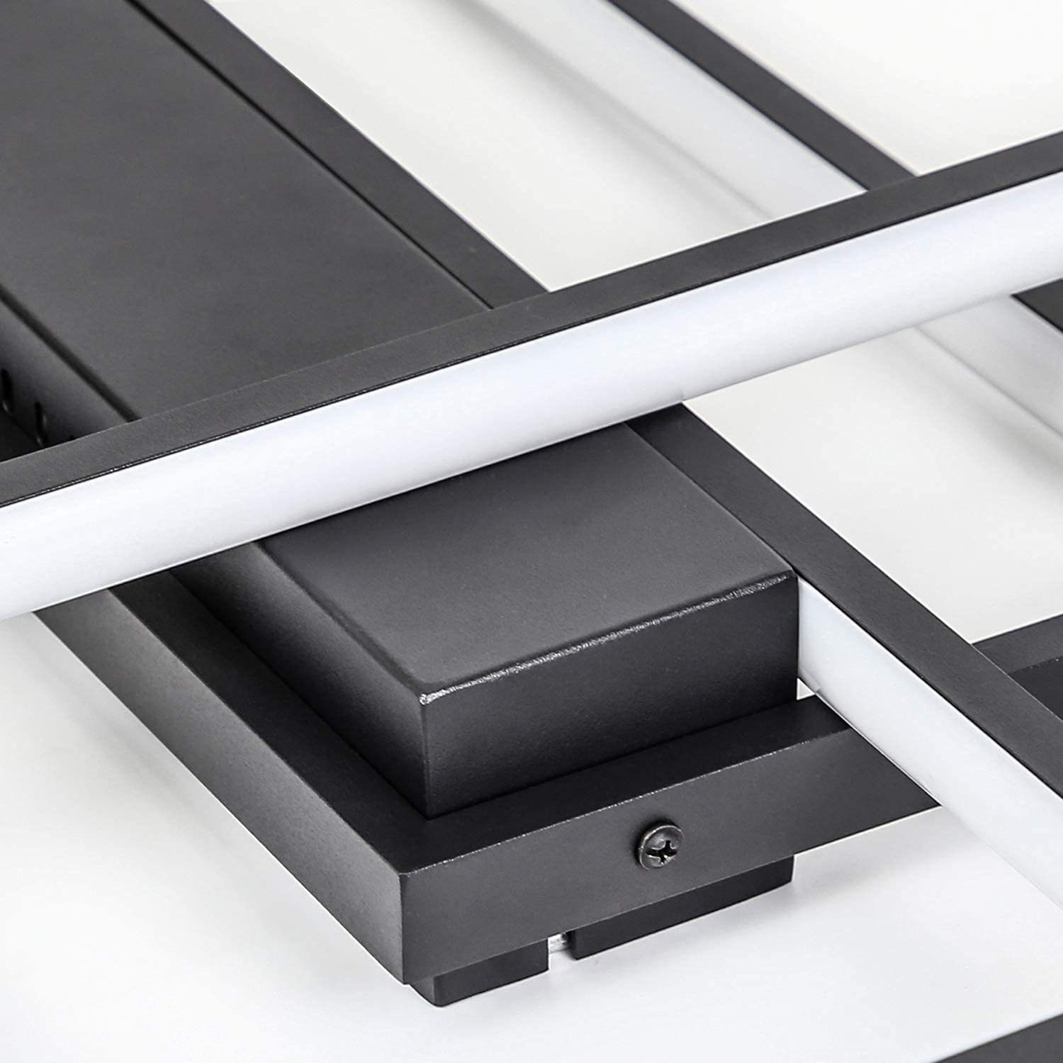 Primer plano de un marco de metal negro con luces LED blancas. Una estructura cuadrada negra está en el centro, con un tornillo lateral.