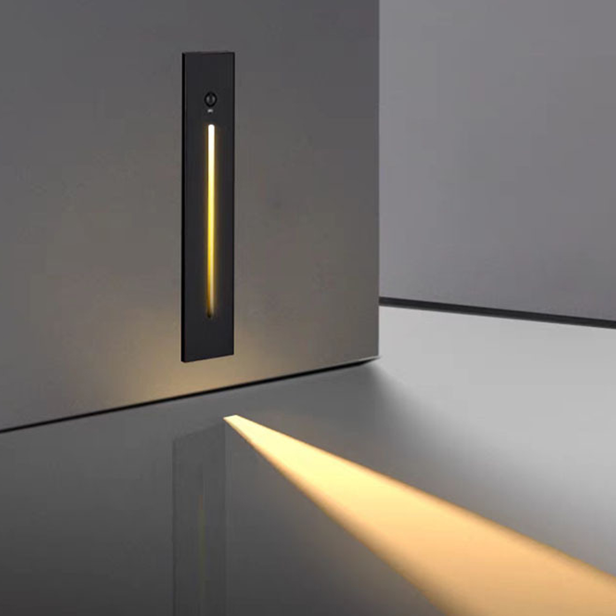 Eine moderne Wandleuchte strahlt einen Lichtstrahl aus. Die schwarze Leuchte hat einen vertikalen Lichtstreifen. Das Licht spiegelt sich.