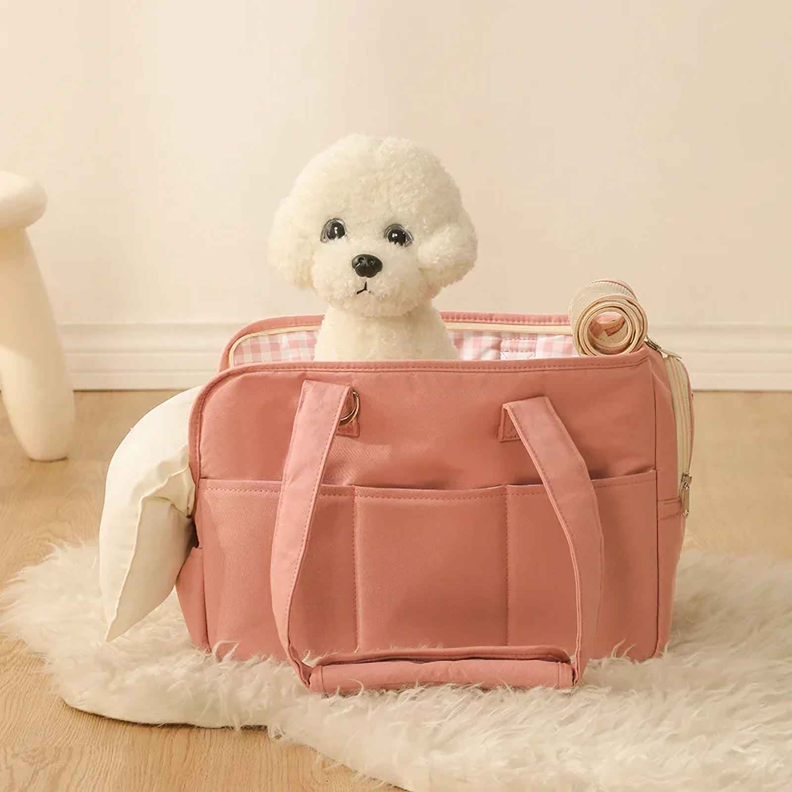 Ein weißer Hund sitzt in einer rosa Haustiertasche. Der Träger liegt auf einem weißen Teppich. Der Hintergrund ist eine helle Wand.