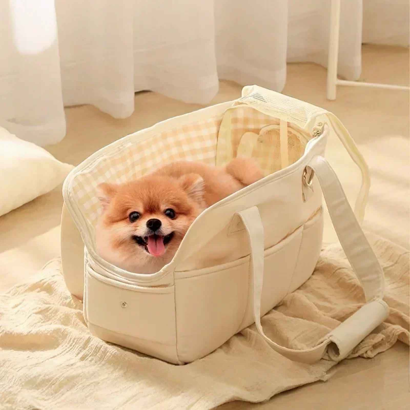 Ein glücklicher Hund in einer beigefarbenen Tragetasche mit Gingham-Innenraum, platziert auf einer beigefarbenen Decke.