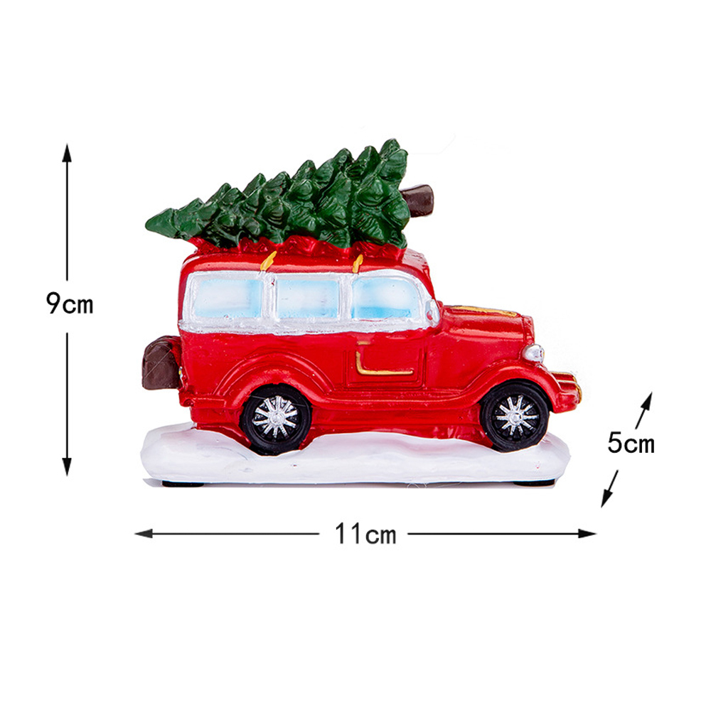 Ein rotes Spielzeugauto mit Weihnachtsbaum auf dem Dach, auf Schnee. Abmessungen: 11 cm, 9 cm, 5 cm.