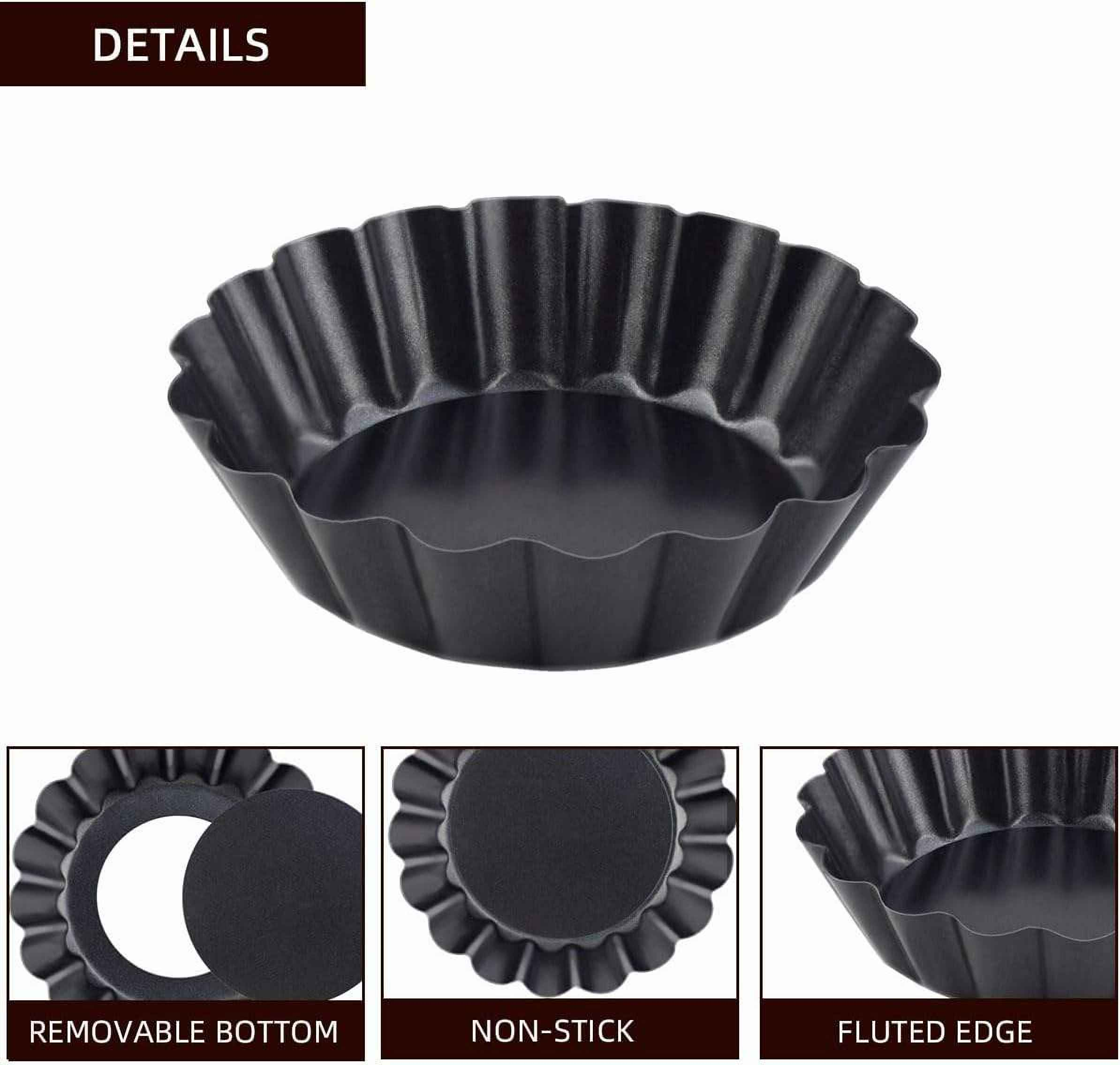 Eine schwarze Tarteform mit gewellten Kanten wird angezeigt. Details zeigen einen herausnehmbaren Boden und eine Antihaftbeschichtung.