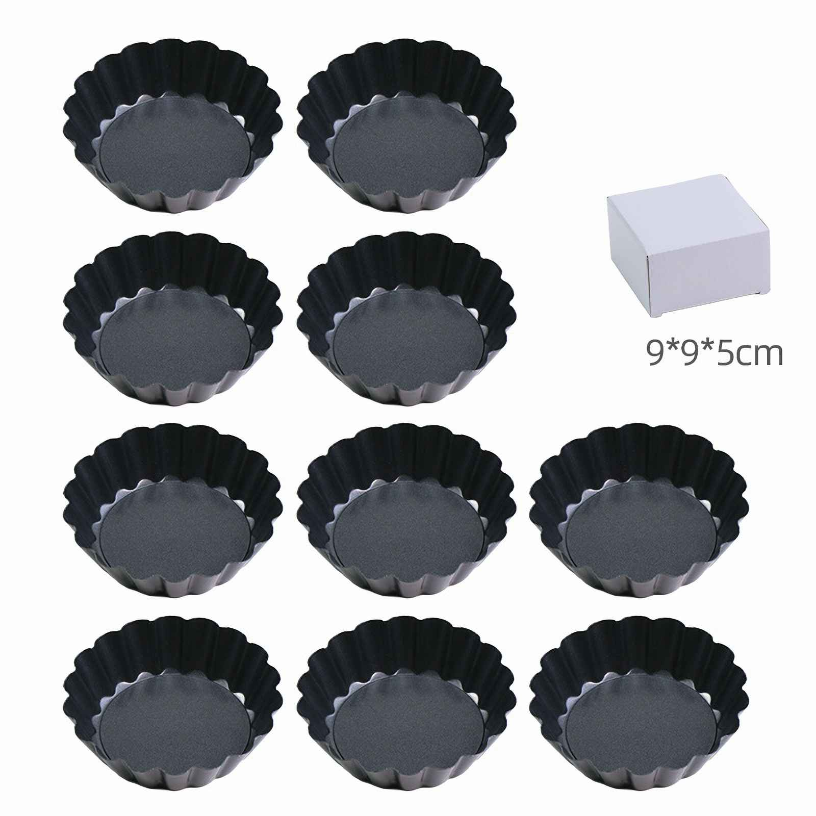 Neun schwarze Tarteformen mit geriffelten Rändern. Eine weiße Schachtel mit 9x9x5cm ist ebenfalls vorhanden.