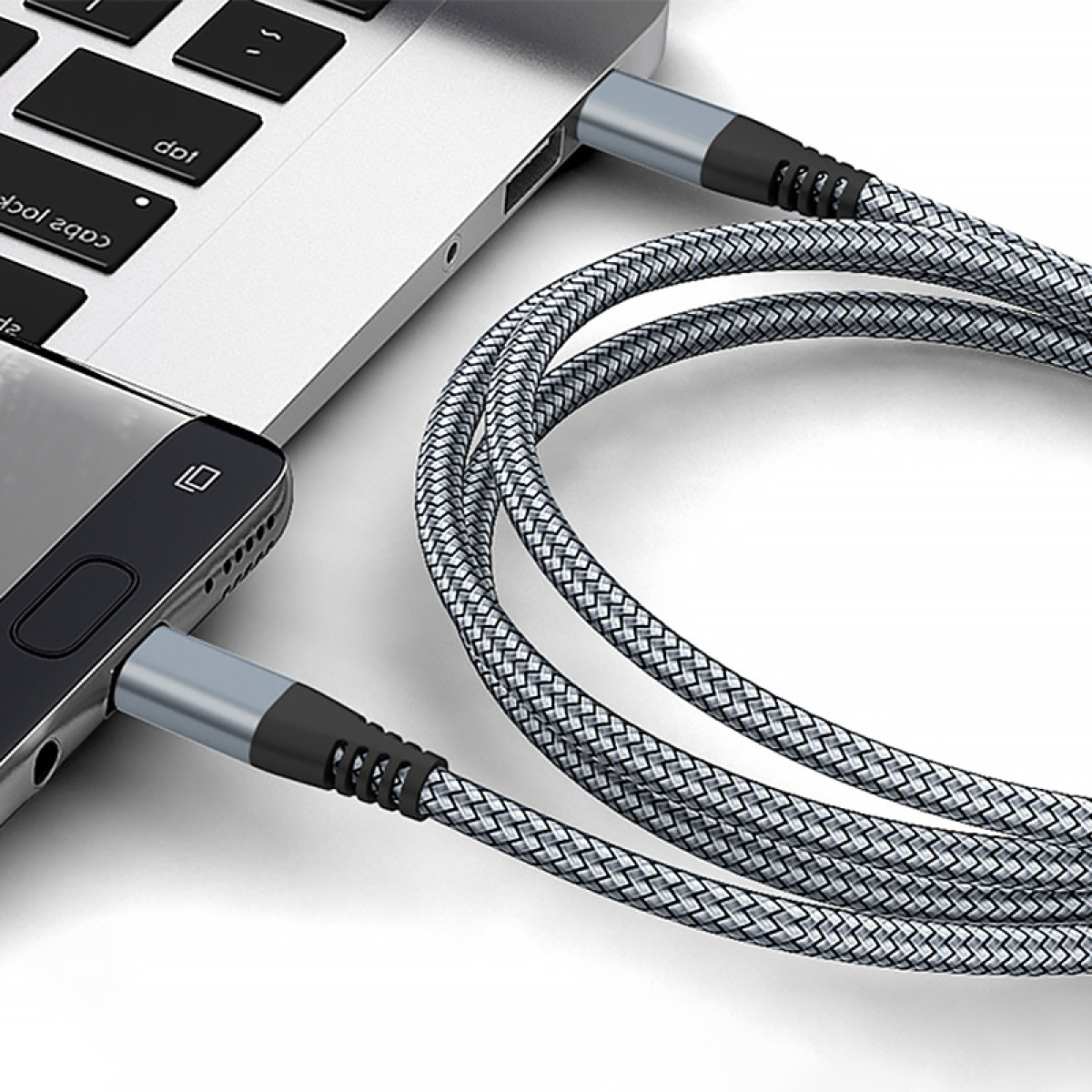 Un telefono e un laptop sono collegati con un cavo di ricarica intrecciato. Il cavo è collegato a entrambi i dispositivi.