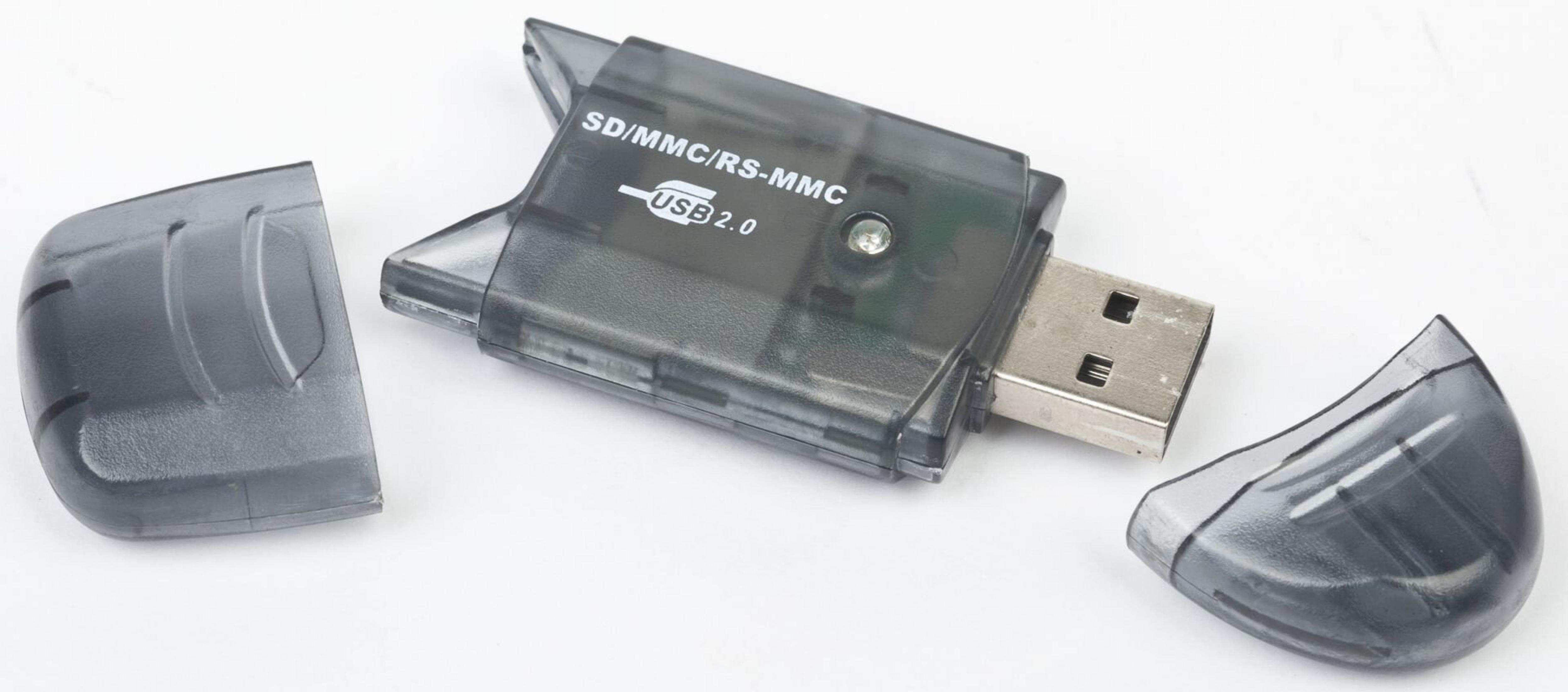 Un lettore di schede USB grigio con due coperchi staccati giace su una superficie bianca. Il lettore è etichettato SD/MMC/RS-MMC USB 2.0.