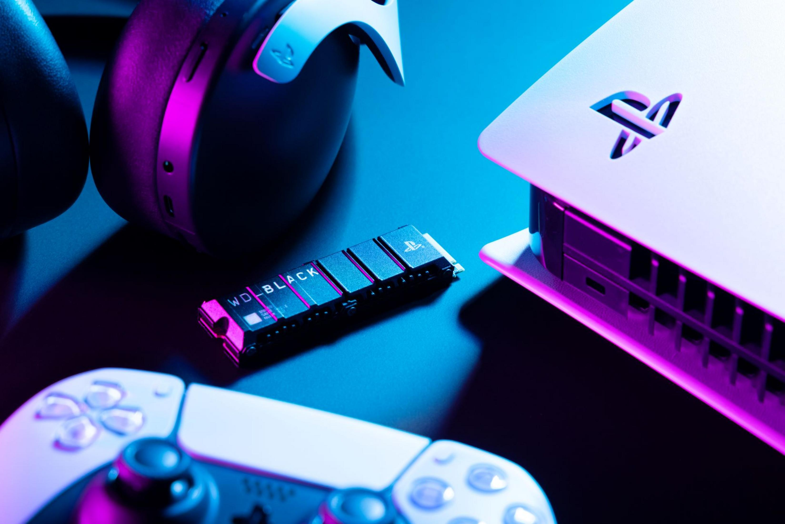 Konfiguracja do gier: PlayStation 5, kontroler, zestaw słuchawkowy i dysk SSD WD_BLACK, podświetlone na niebiesko i fioletowo.